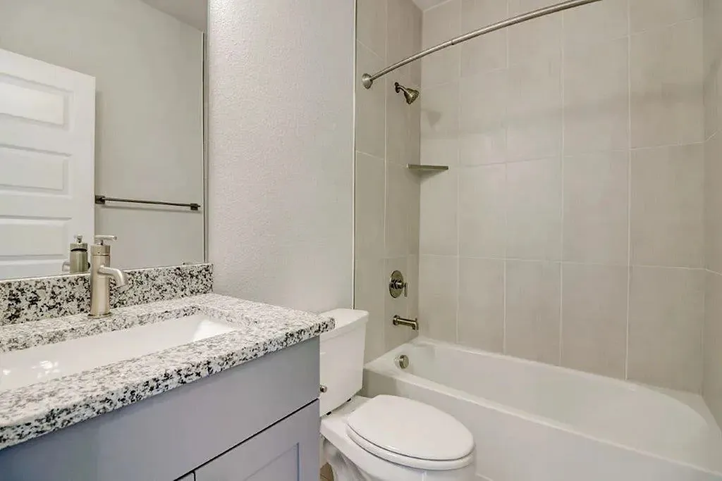 Vanity with speckled countertop, undermount sink, and brushed nickel faucet