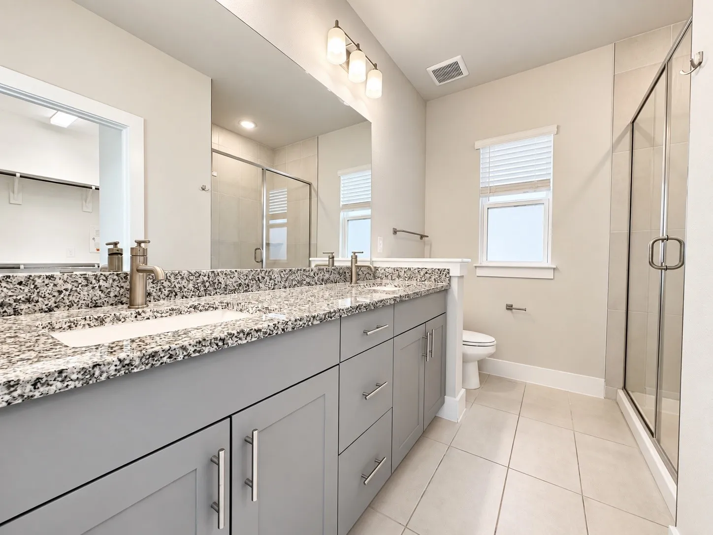 Dual vanity with granite countertop and brushed nickel fixtures