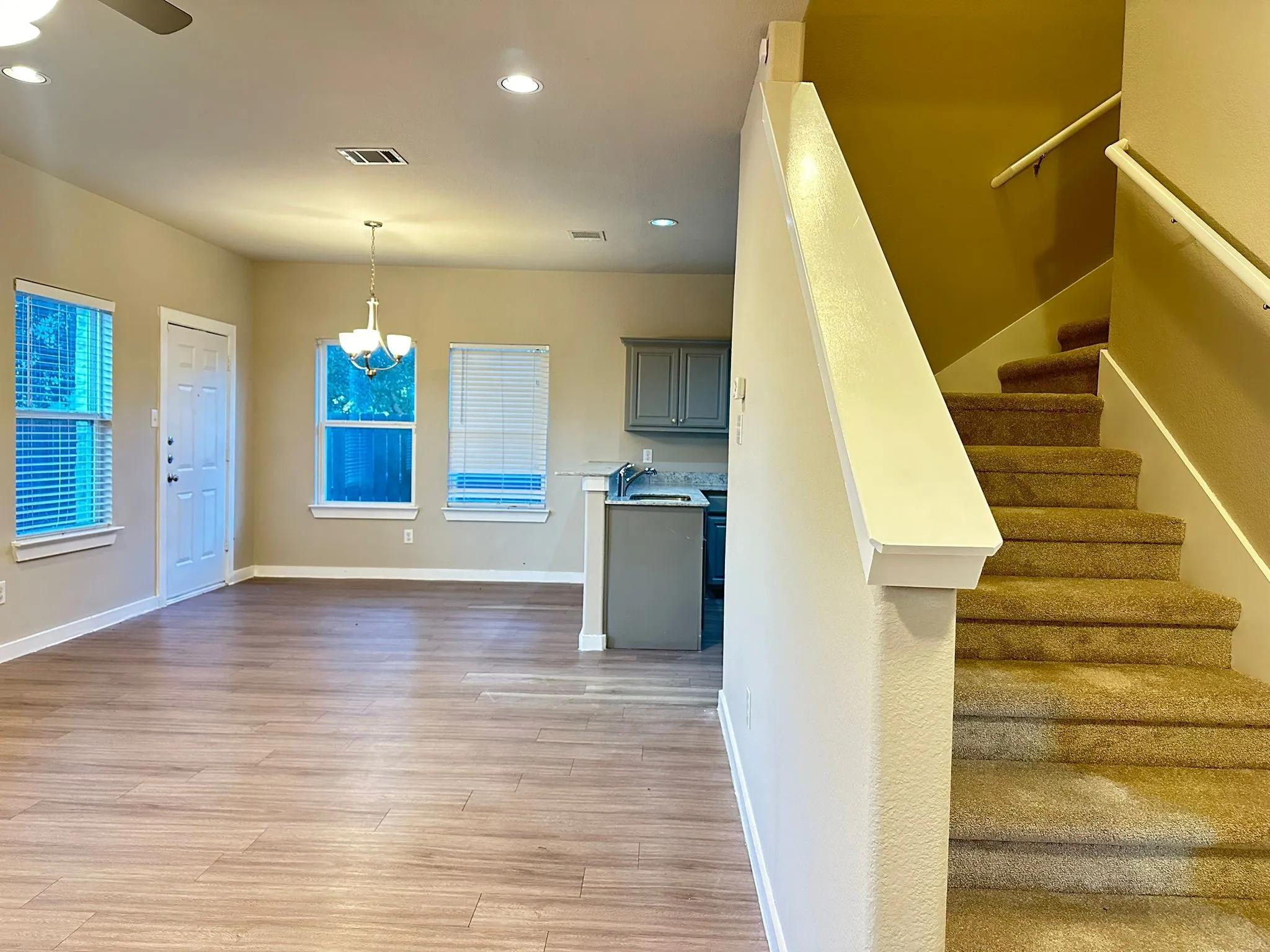 Open-concept living area with wood-finish flooring, recessed lighting, and ceiling fan