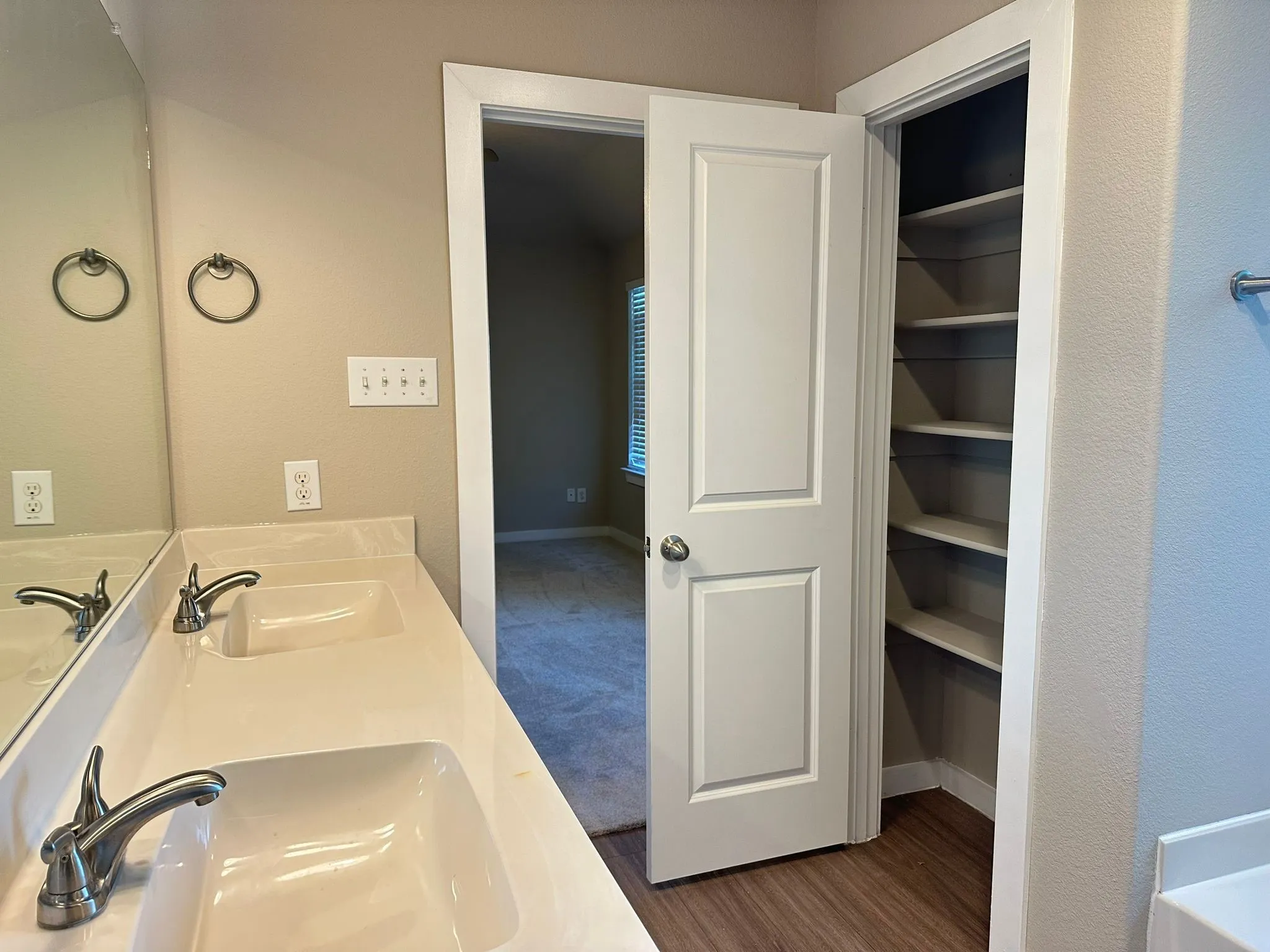 Dual vanity with integrated sinks, brushed nickel faucets, and an expansive mirror