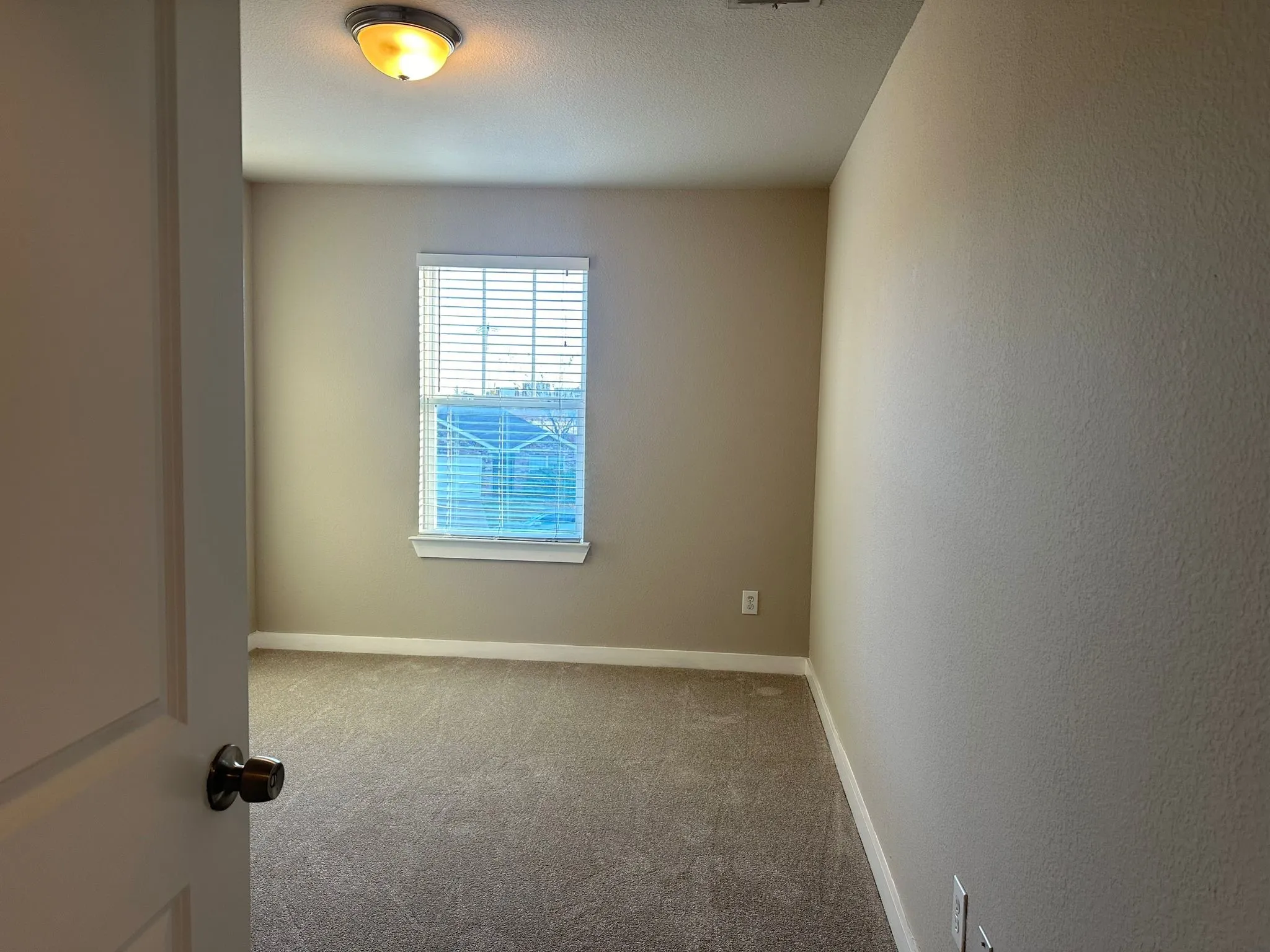 Neutral-toned walls complement the textured carpeting