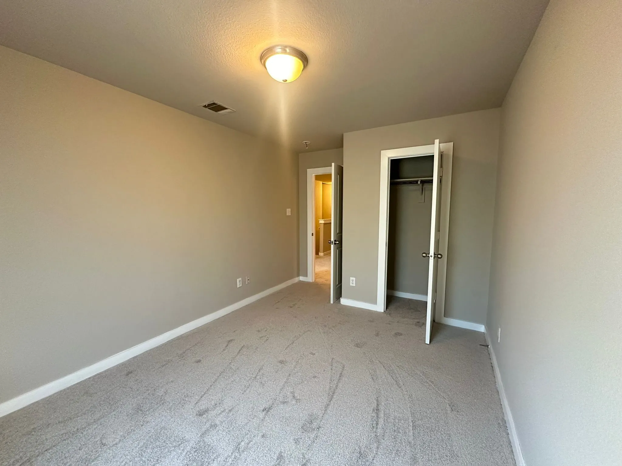 Neutral-toned walls complement the light gray carpeting