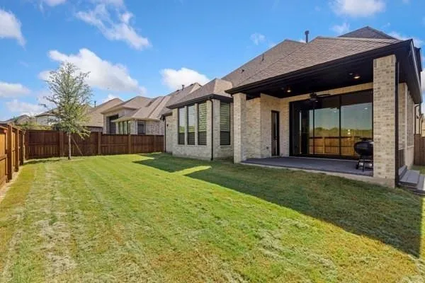Expansive backyard featuring a wood privacy fence and a young tree