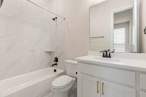 White vanity with a solid surface countertop, an undermount sink, and matte black faucet