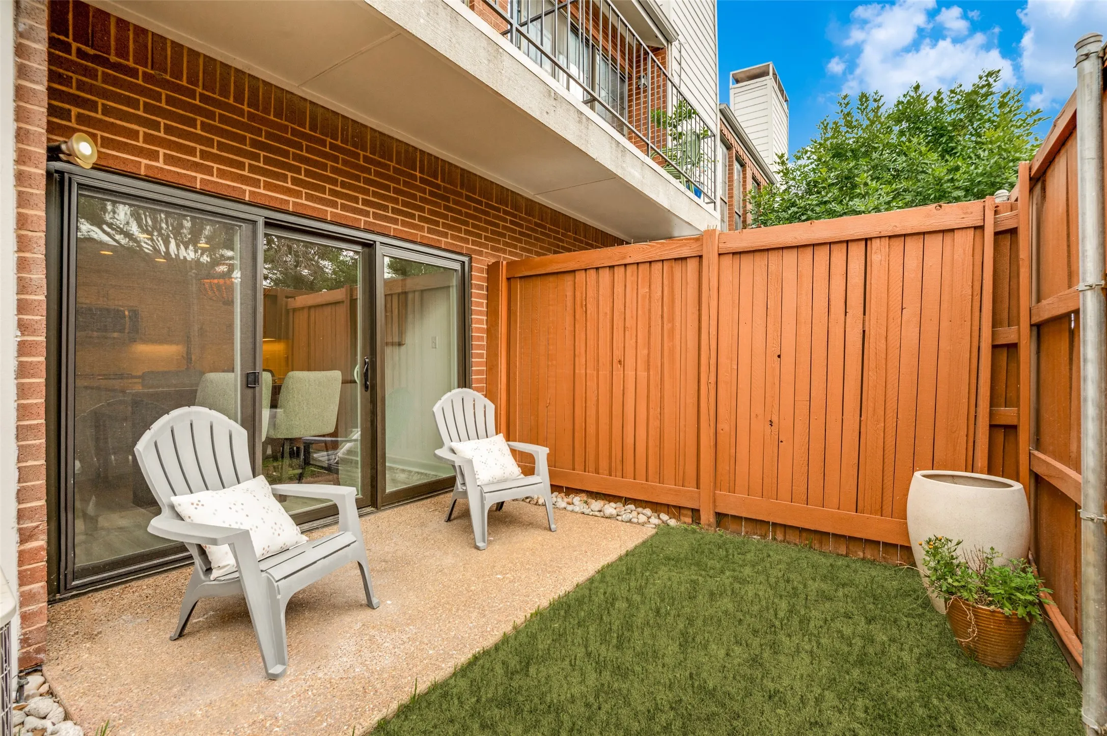 Step outside and enjoy your own private outdoor retreat. This charming fenced patio offers the perfect blend of privacy and low-maintenance living, featuring a cozy seating area ideal for morning coffee, evening conversations, or simply unwinding after a long day. Sliding glass doors create a seamless connection to the interior living spaces, extending your entertaining options outdoors.