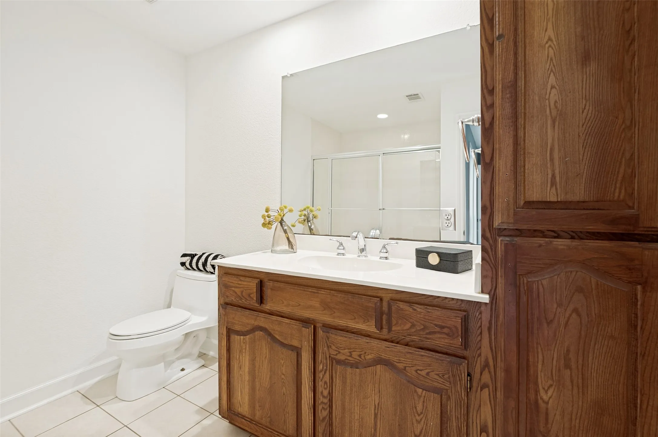 The spacious ensuite bath offers a clean and functional design with plenty of room to start and end your day in comfort. A large vanity with generous counter space and abundant storage is complemented by an oversized mirror that enhances the bright, open feel of the room.