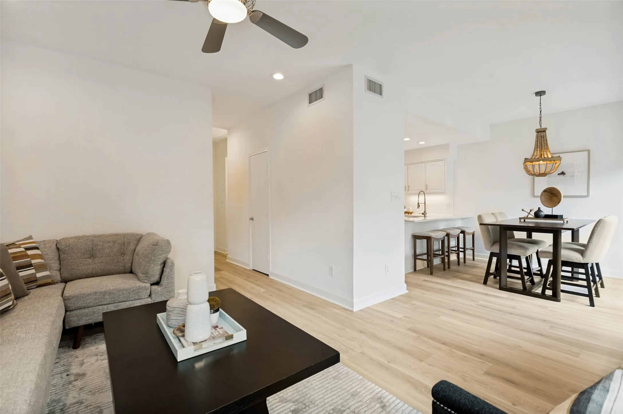 The light luxury vinyl plank flooring flows seamlessly throughout the home, creating a bright and cohesive foundation that enhances the open-concept design. The spacious living and dining areas connect effortlessly to the beautifully updated kitchen, offering an ideal layout for both everyday living and entertaining.