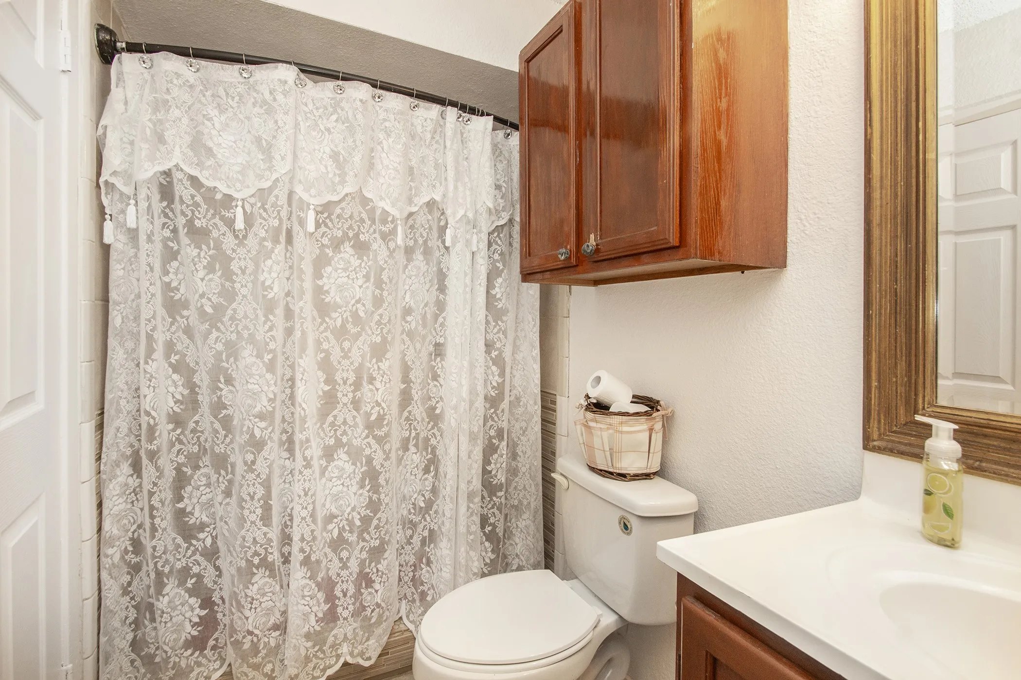 Bathroom featuring a built-in vanity with white countertop, integrated sink, and wood-finish cabinetry