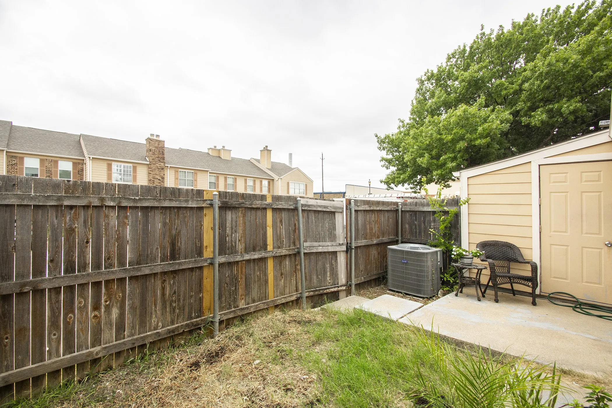 Enclosed yard featuring a wood fence, concrete patio, and a detached storage shed