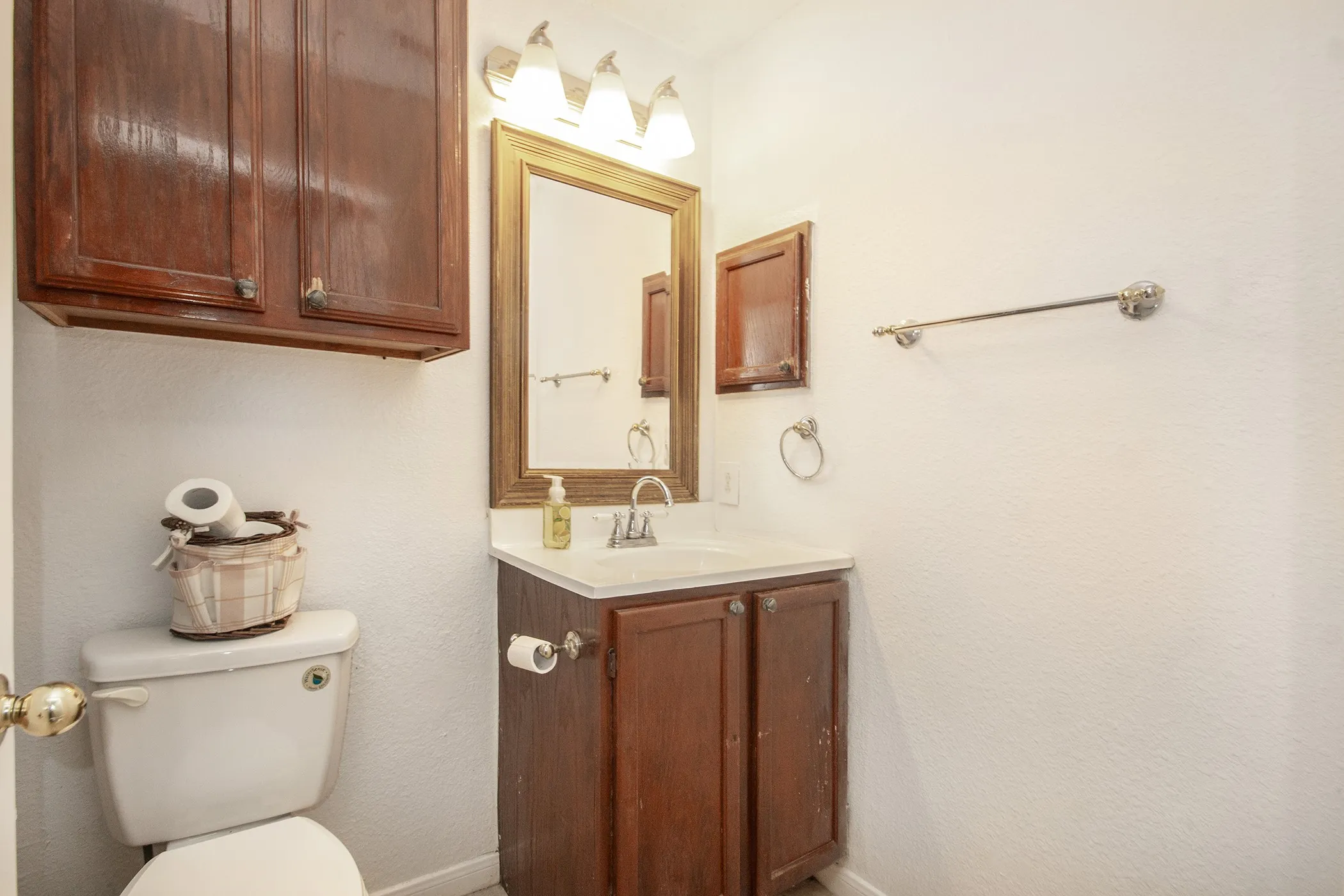 White toilet with a wall-mounted wood-finish cabinet