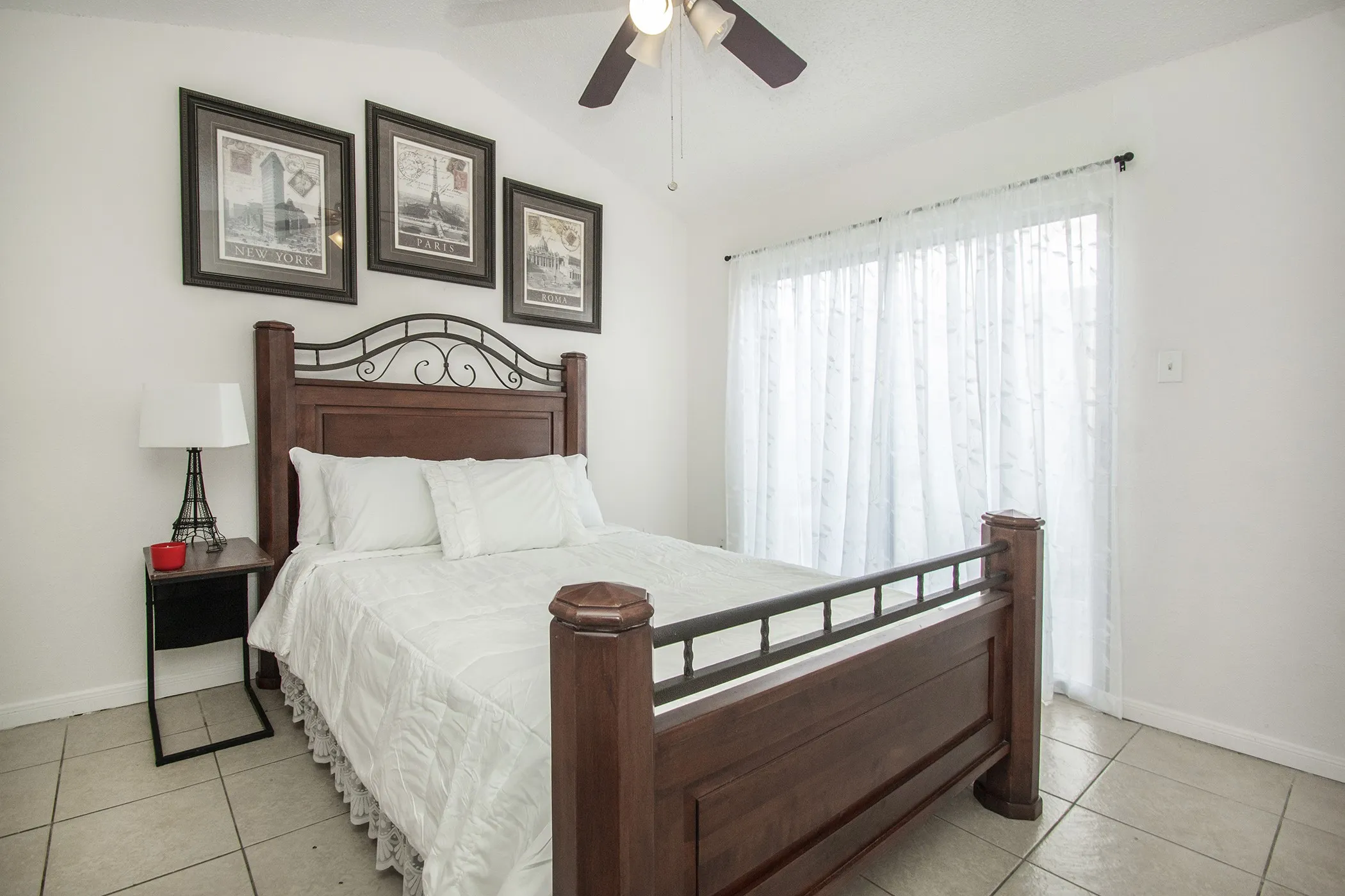 Tiled flooring, vaulted ceiling, ceiling fan, and white walls
