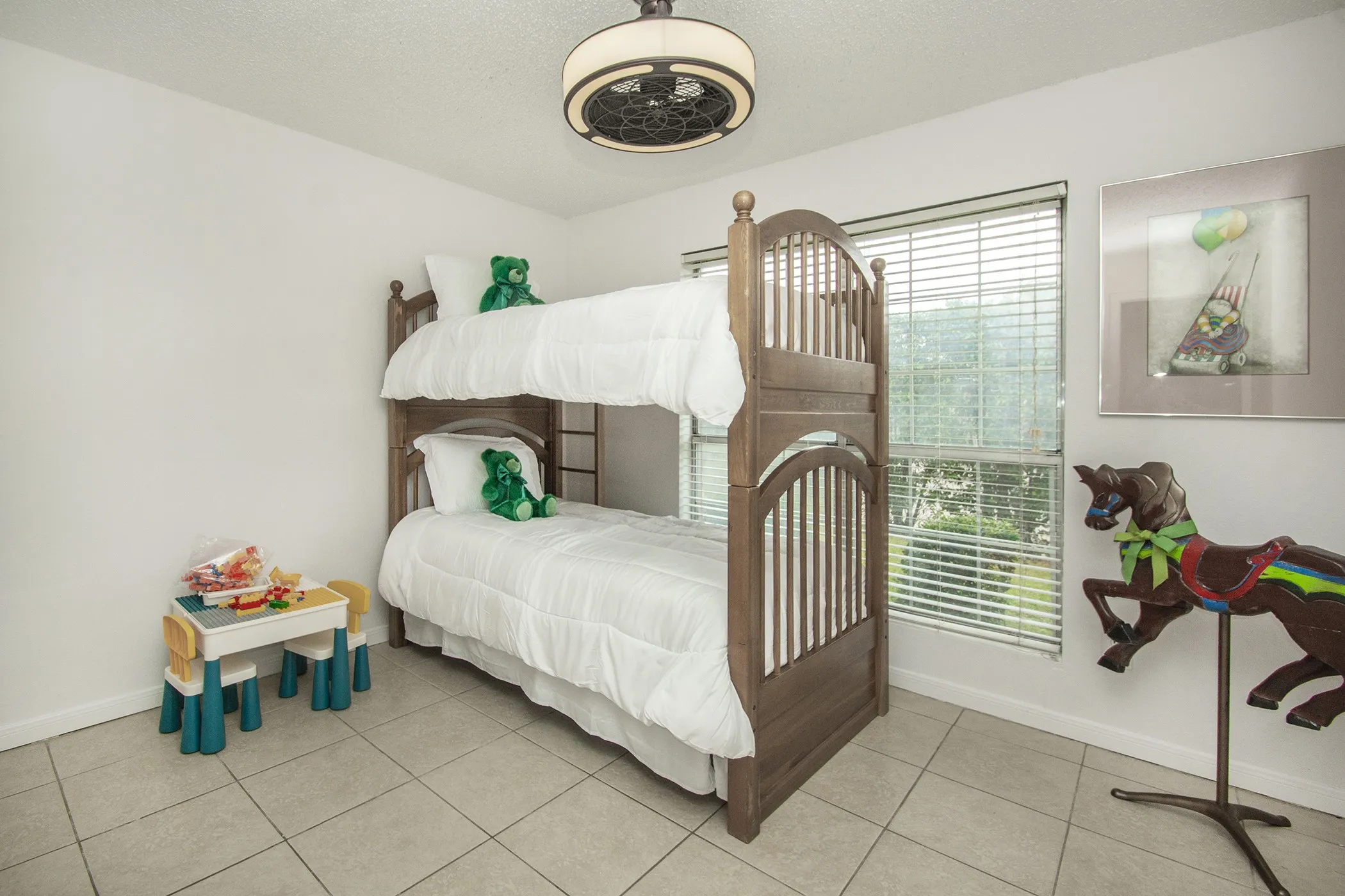 Room featuring tiled flooring, a window with horizontal blinds, and a ceiling-mounted fan with integrated lighting