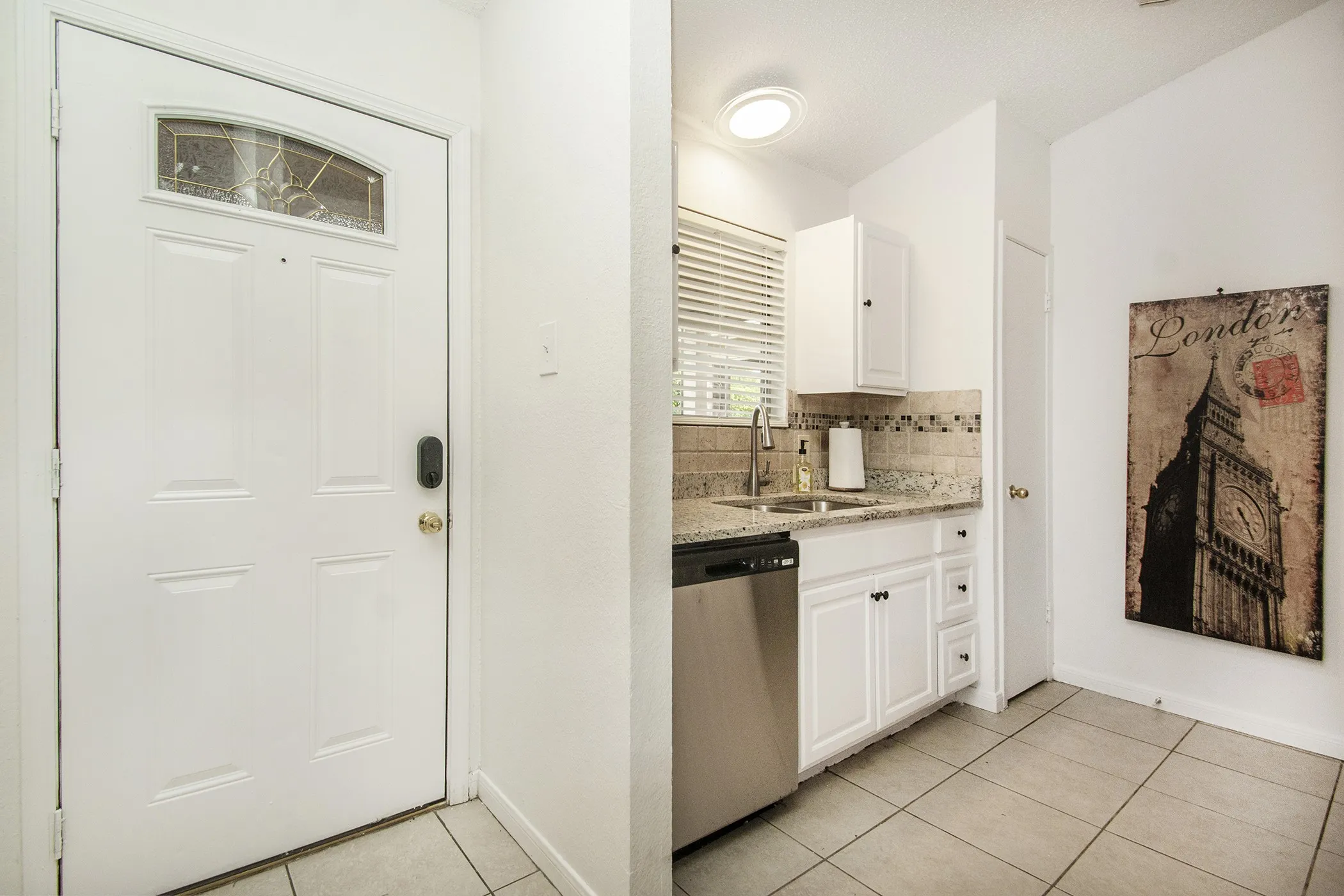 White paneled entry door with decorative glass insert