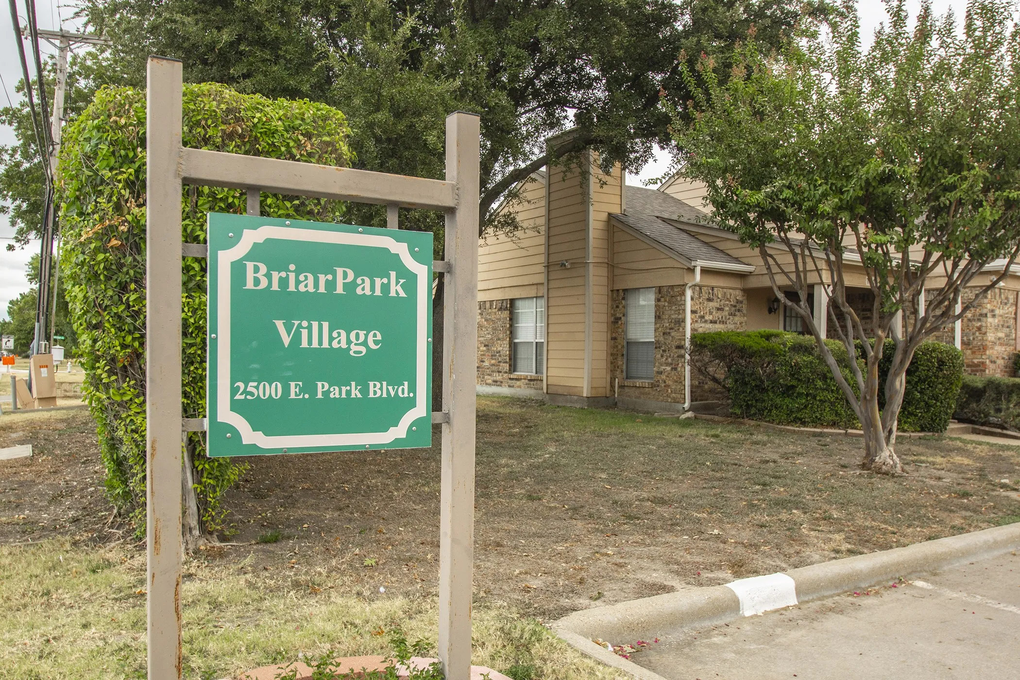 Community entrance sign with stone and siding exterior