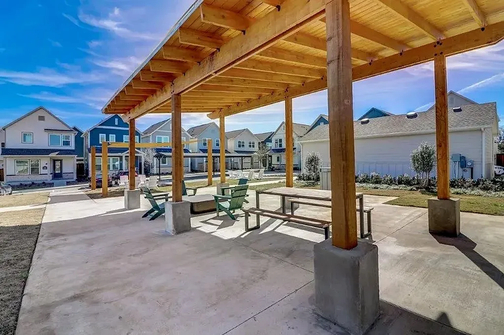 Pergola-covered concrete patio area featuring exposed wood beams and posts