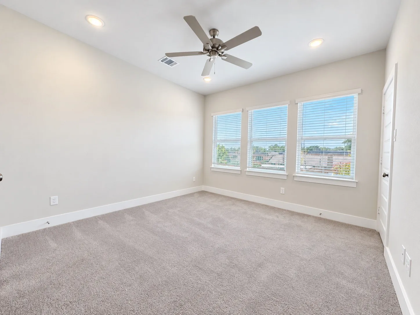 Plush carpet flooring complements neutral wall tones