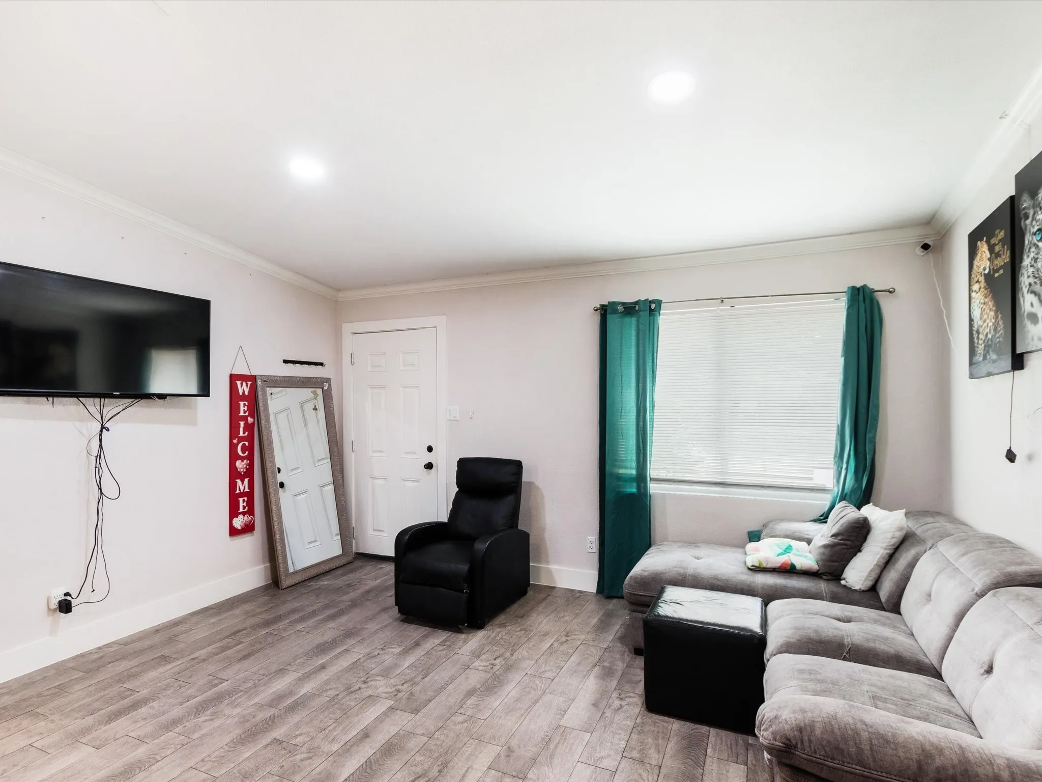 Recessed lighting throughout, wood-finish flooring, and a window with blinds provide illumination
