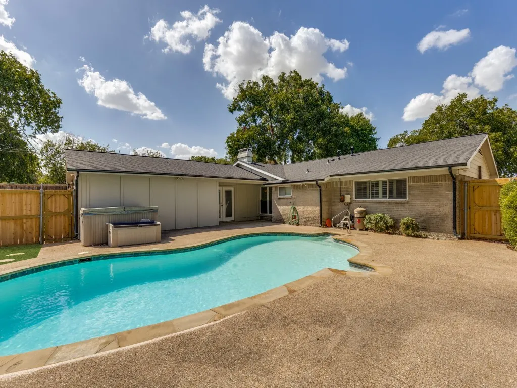 Swimming pool with a stone coping and adjacent concrete decking
