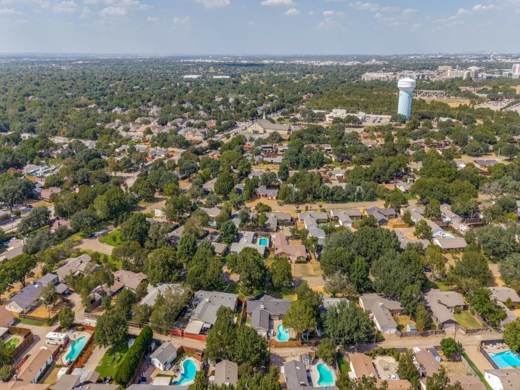 Expansive residential area featuring numerous mature trees, a water tower landmark, and multiple properties with private pools