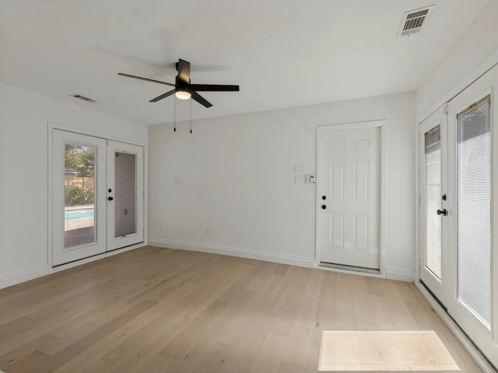 Light wood-finish flooring with white walls and trim