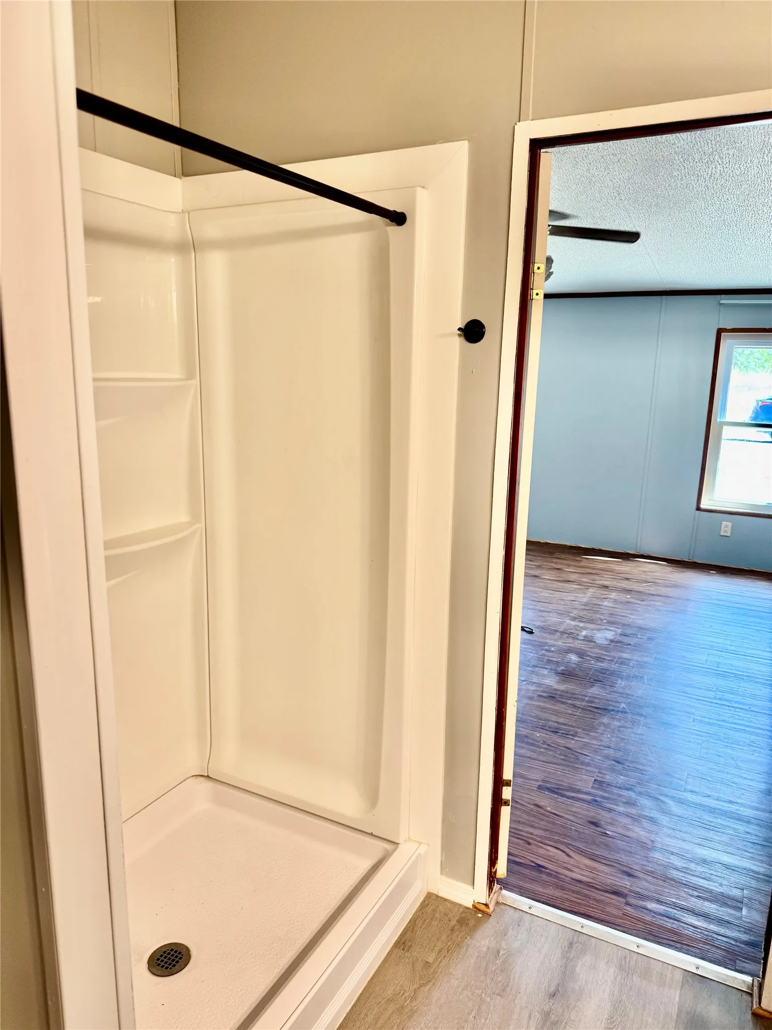 White fiberglass shower stall with built-in shelving