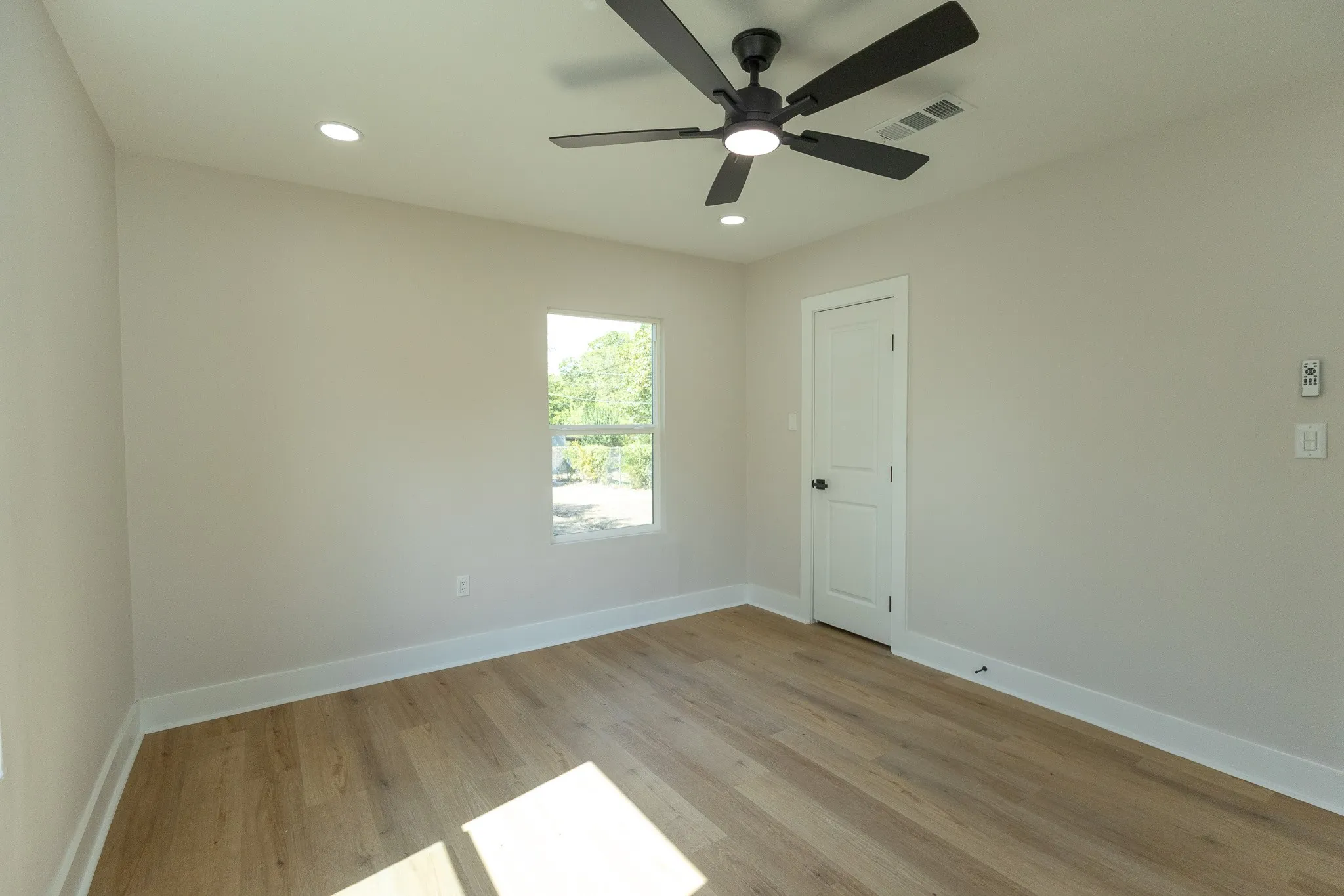 Wood-finish flooring with white trim, recessed lighting, and a modern ceiling fan