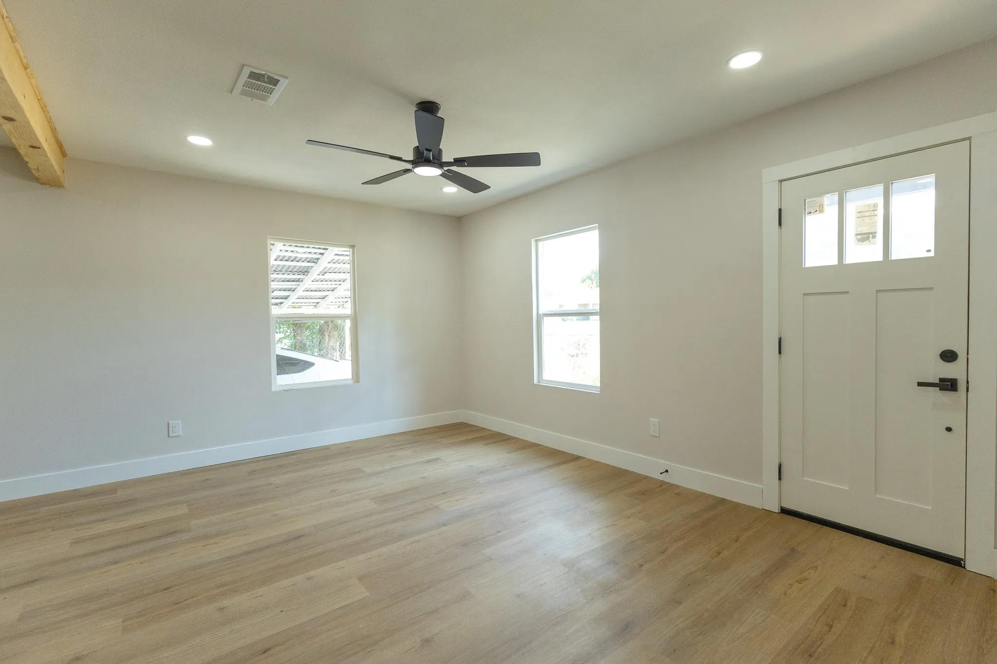 Wood-finish flooring, recessed lighting, and a matte black ceiling fan
