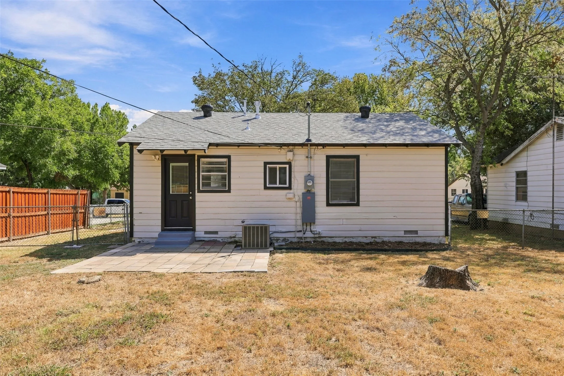 Rear exterior with a paved patio area and white siding