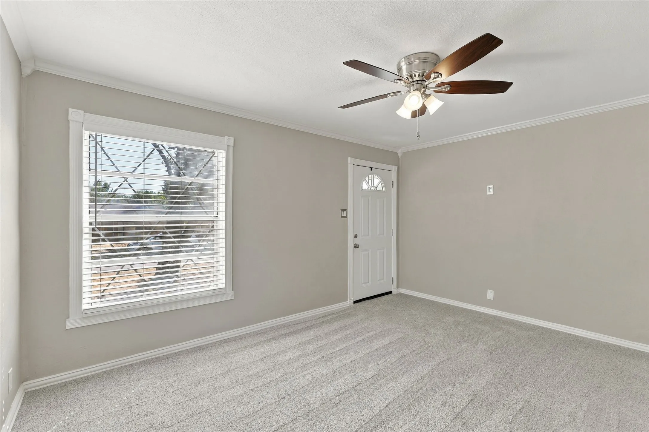 Light gray wall paint, white trim, light gray carpeting, and a ceiling fan with light fixture