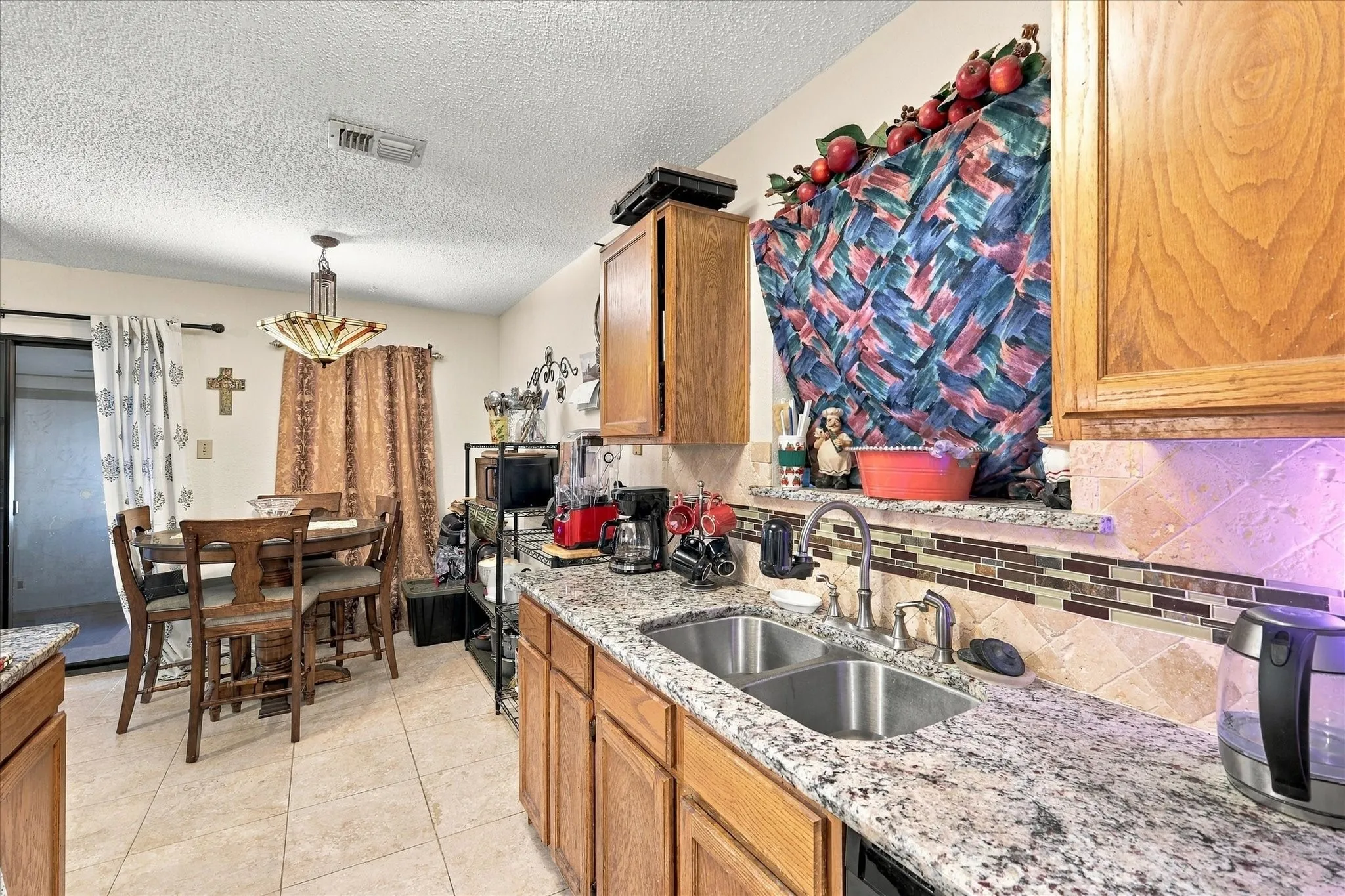 Kitchen featuring wood cabinetry, granite-style countertops, and a tiled backsplash