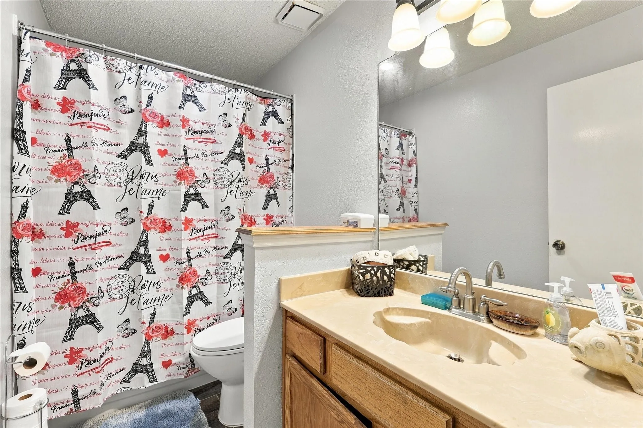 Vanity featuring a single basin sink and a large wall-mounted mirror