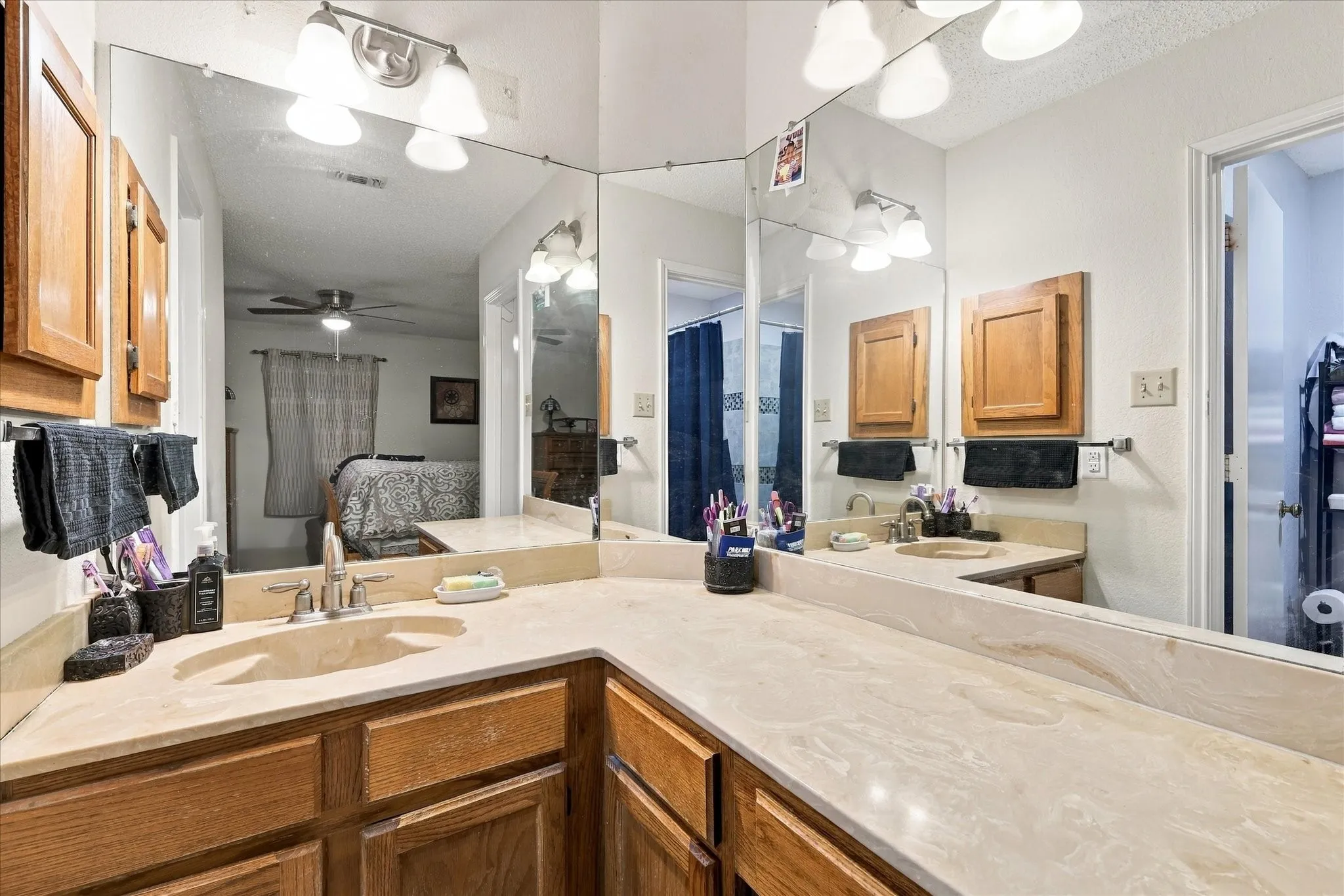 Dual vanity with integrated sinks, light-toned countertop, and wood-finish cabinetry