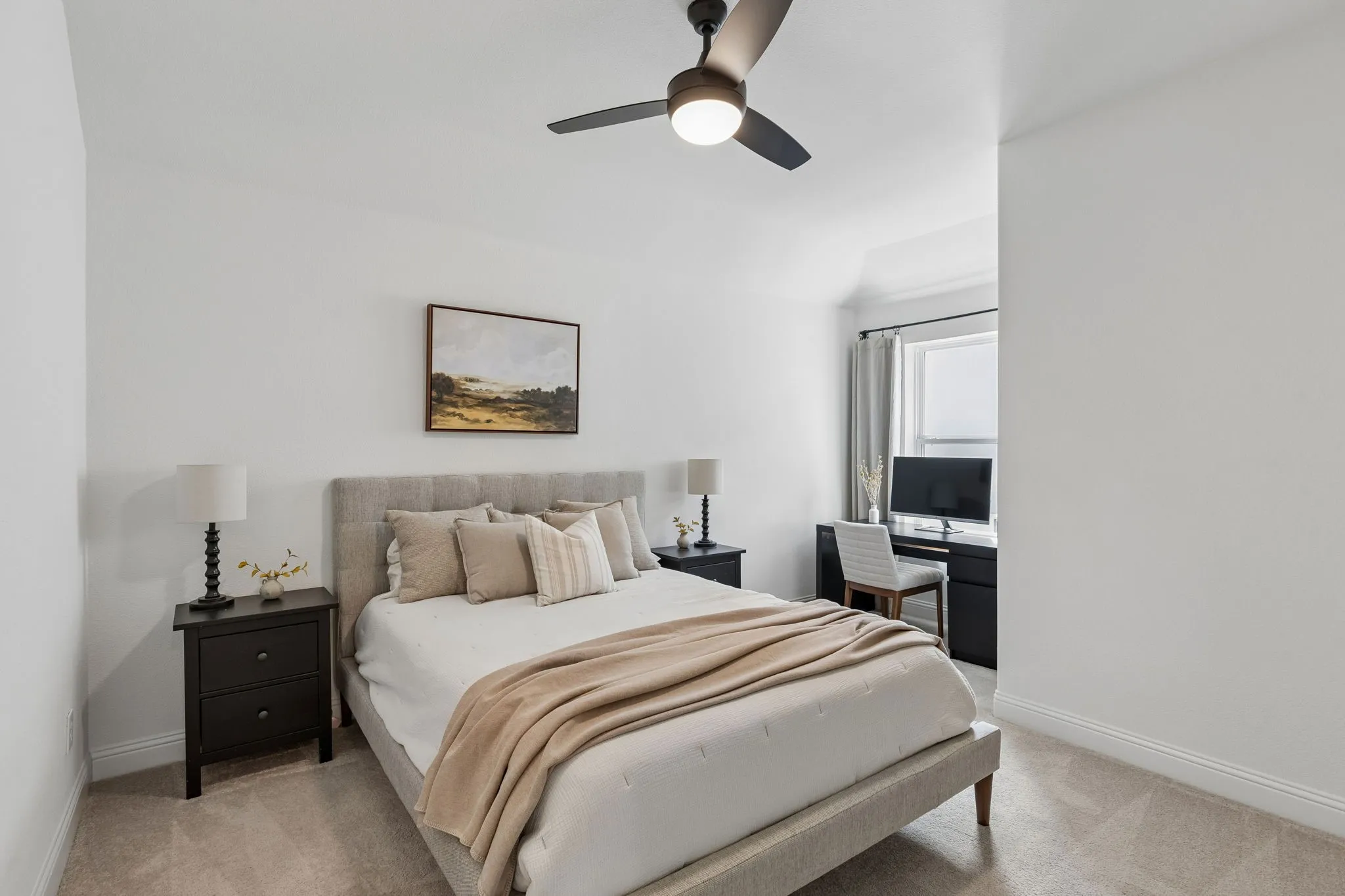 Inviting bedroom with an ensuite showcases a soft neutral color palette, generous natural light, and a dedicated desk area—an ideal combination of comfort and functionality.