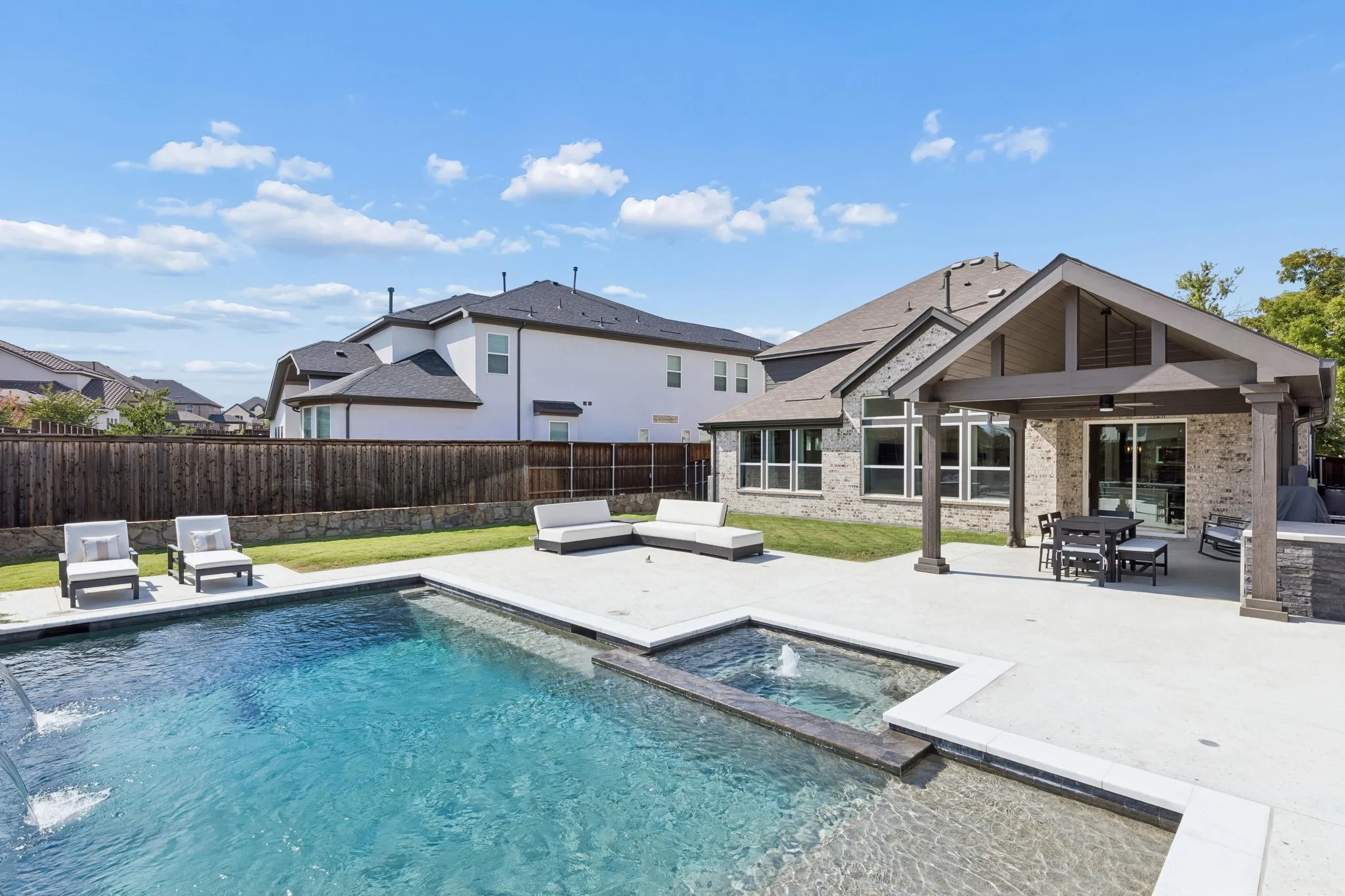 Private backyard delivers a true resort-style experience with a sparkling swimming pool, spa, expansive patio, manicured lawn, mature landscaping, and multiple areas for outdoor entertaining and relaxation.