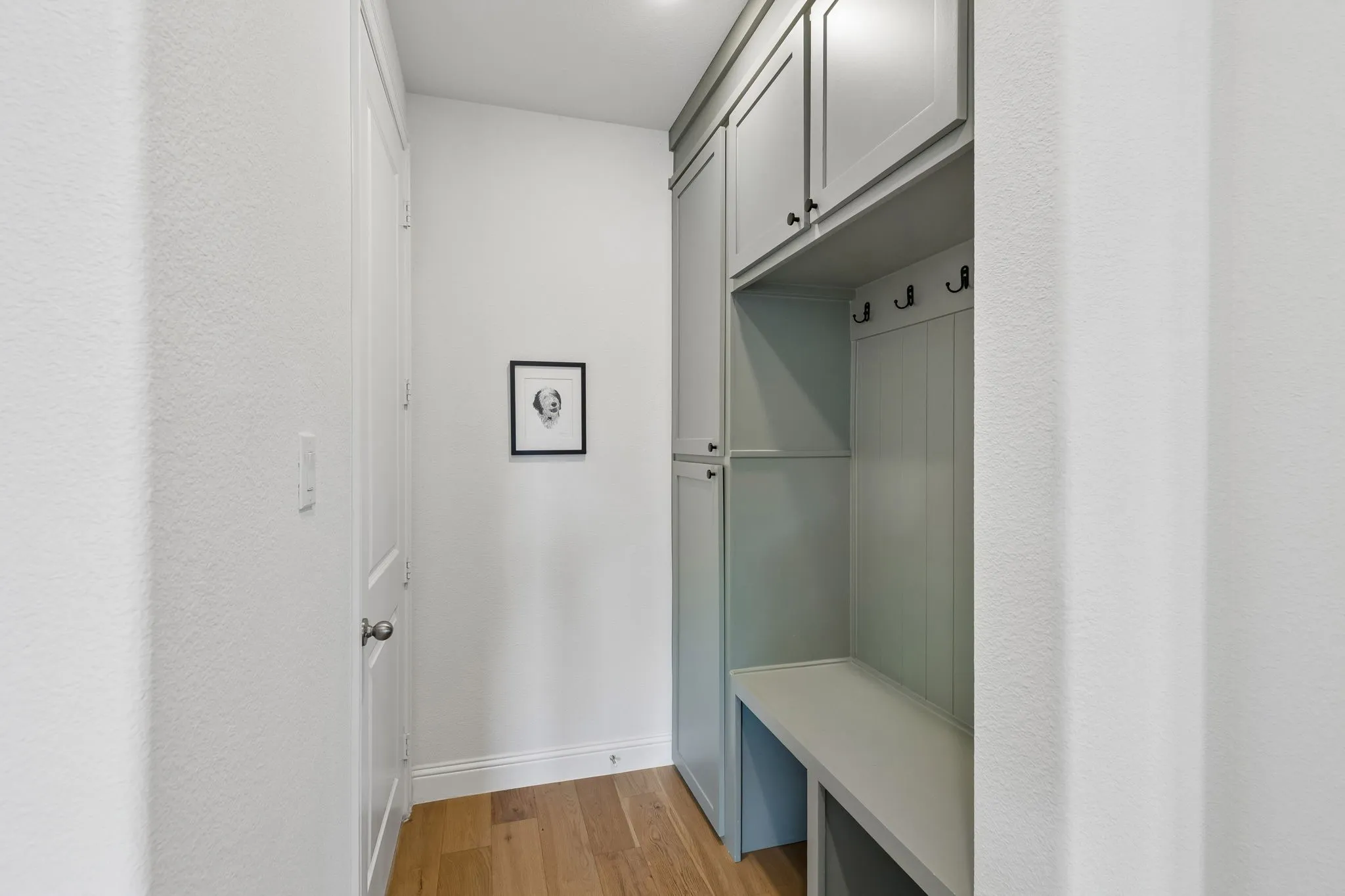 Thoughtfully designed mudroom provides a practical drop zone with built-in cabinetry, bench seating, cubbies, and hooks—an organized and functional transition space for everyday life.