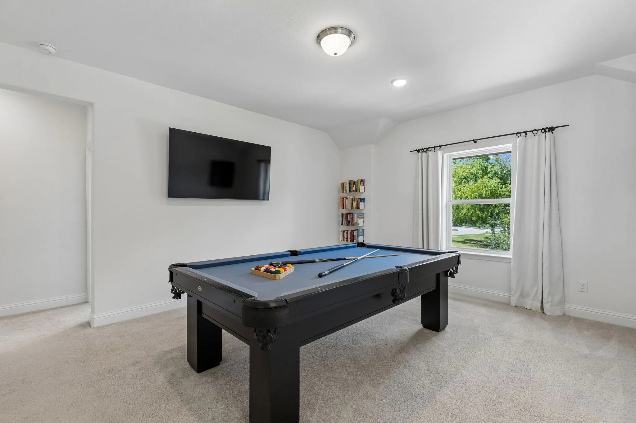 Perfectly suited for entertaining and unwinding, the spacious game room offers generous room for a full-size pool table, media area, and additional seating. Large windows fill the space with natural light while the neutral finishes create a versatile backdrop for game nights, movie marathons, and relaxed gatherings.