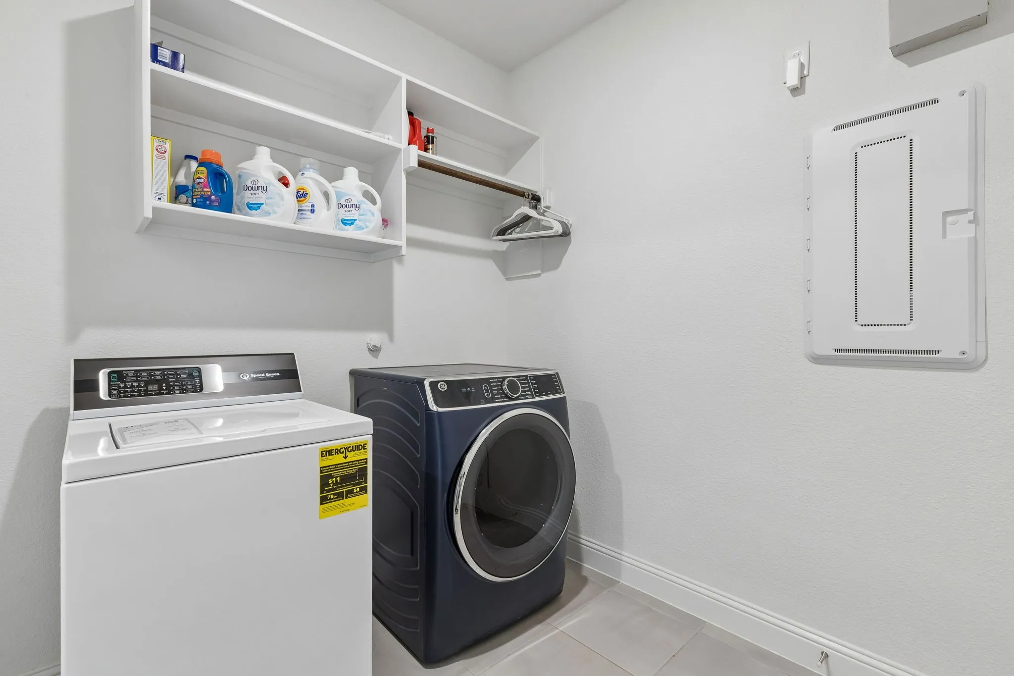 A dedicated first floor laundry room makes everyday living effortless, offering full-size washer and dryer connections, built-in shelving, hanging space, and additional room for household essentials. Bright, clean finishes keep this hardworking space both practical and inviting.