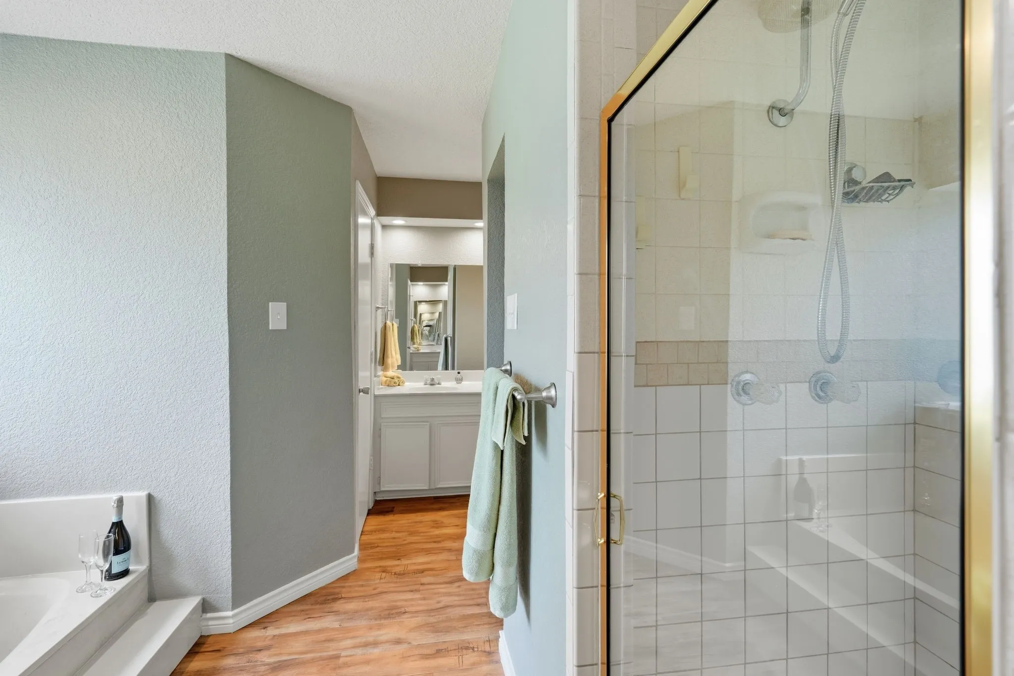 Primary en-suite with garden bathtub and separate glass-enclosed shower with tile surround