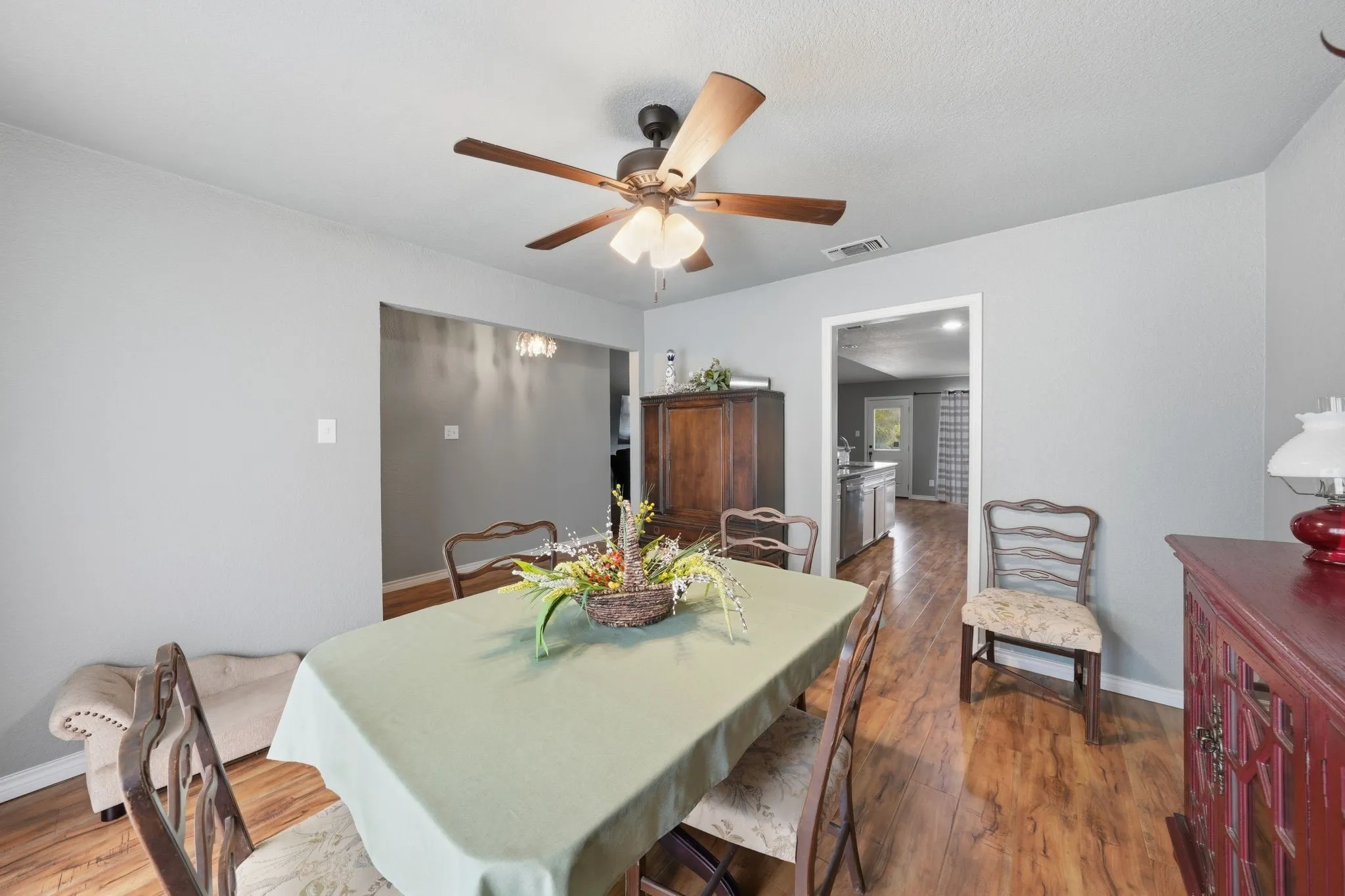 Formal Dining Room with Wood-finish flooring with light gray walls, an overhead ceiling fan, and recessed entryways