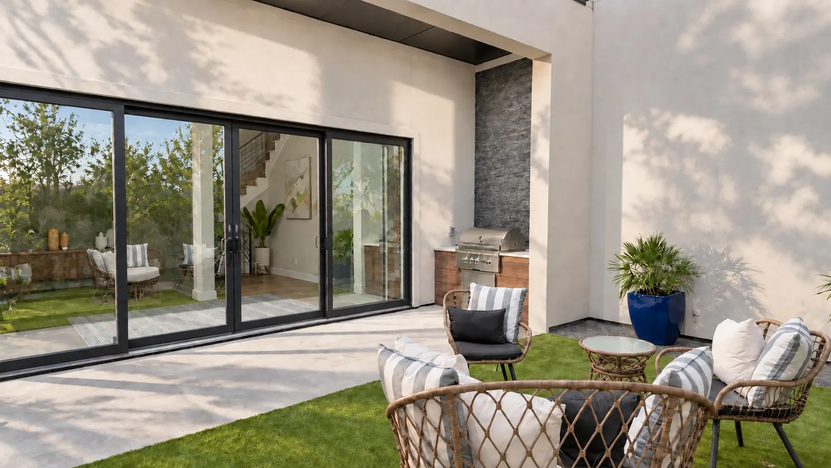 Outdoor patio featuring a built-in grill station with a stone-accented wall and sliding glass doors
