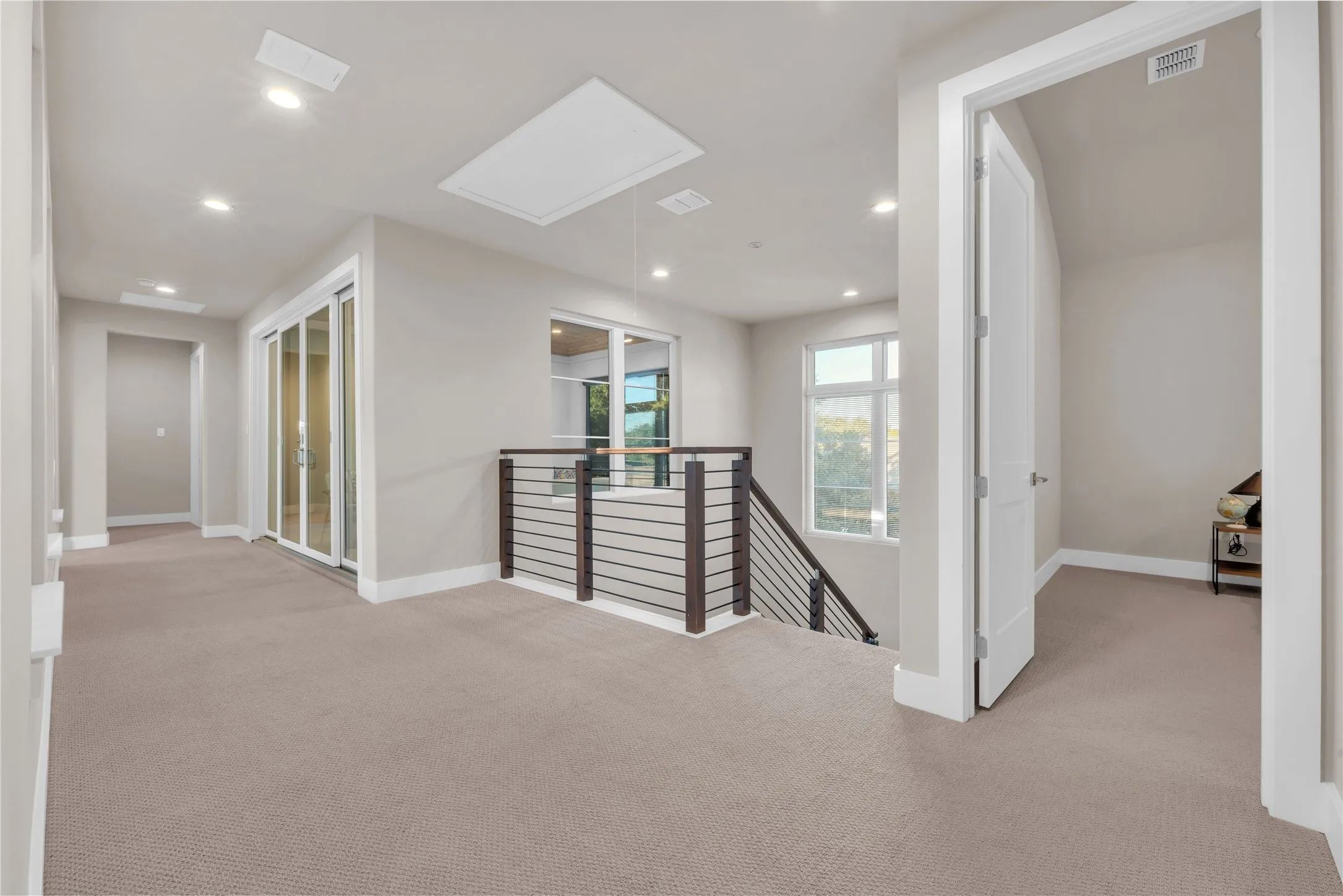 Neutral-toned carpeting, recessed lighting, and a skylight illuminate this upper-level space with 3 bedrooms, 2 patios, and gameroom