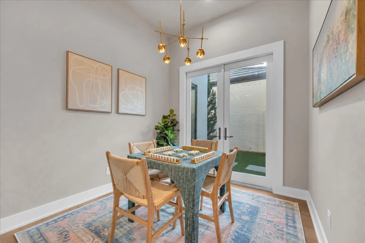 Majhong room Hardwood-finish flooring, contemporary chandelier, double glass-paneled doors, and a private outdoor area featuring artificial turf and stepping stones
