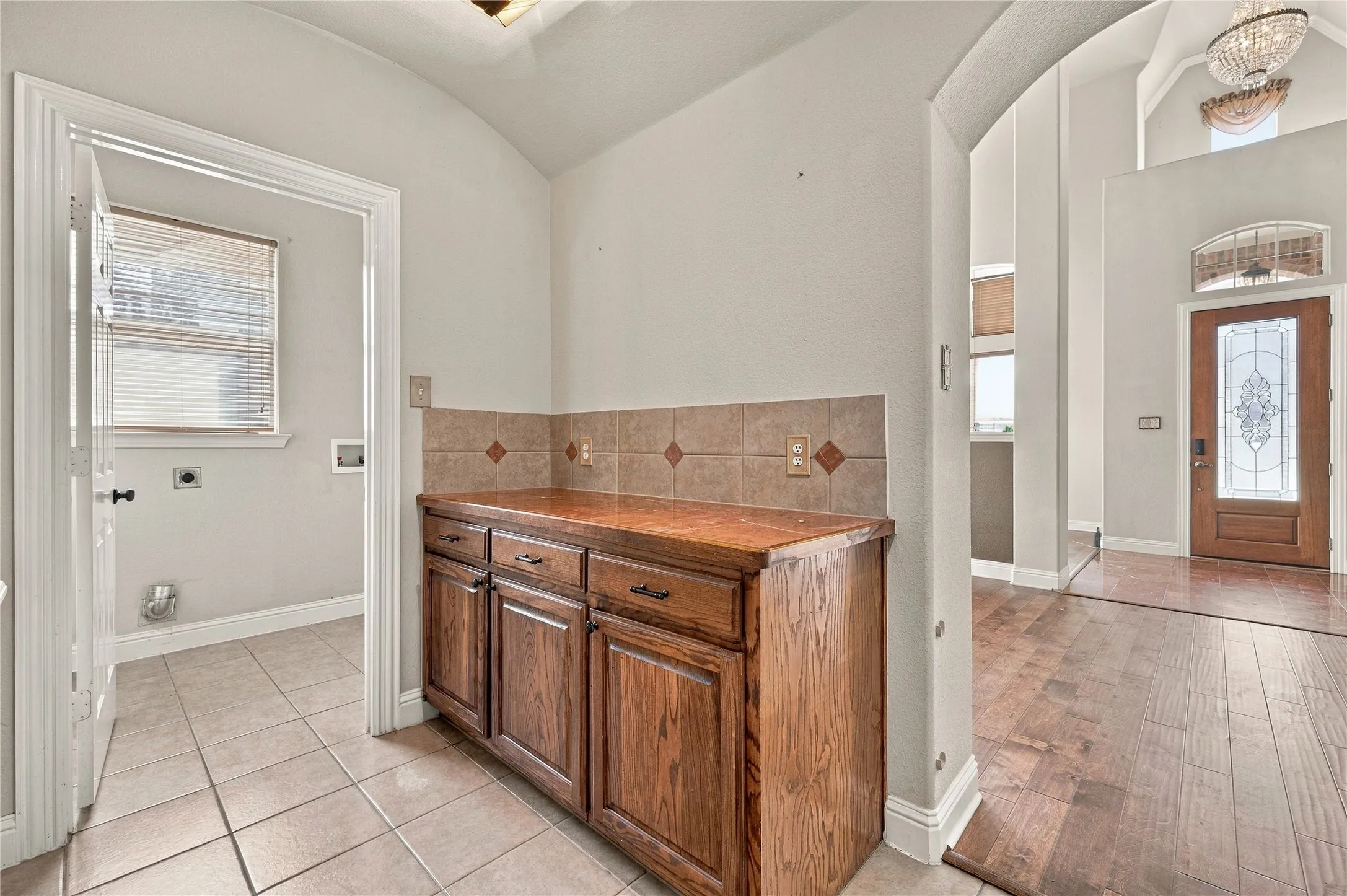 Wood-finish cabinetry with a tile backsplash