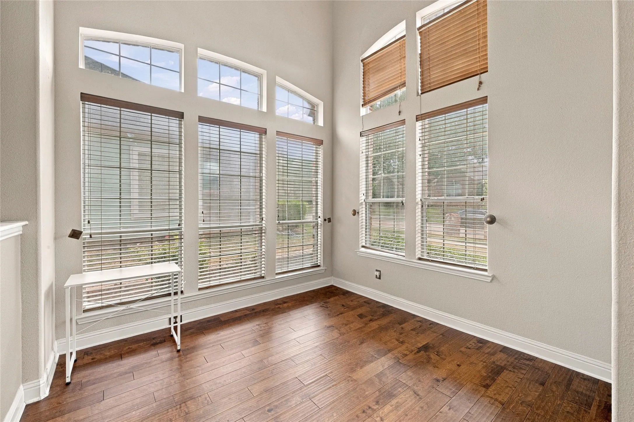 High ceilings, large windows, wood-finish flooring, and light-toned walls