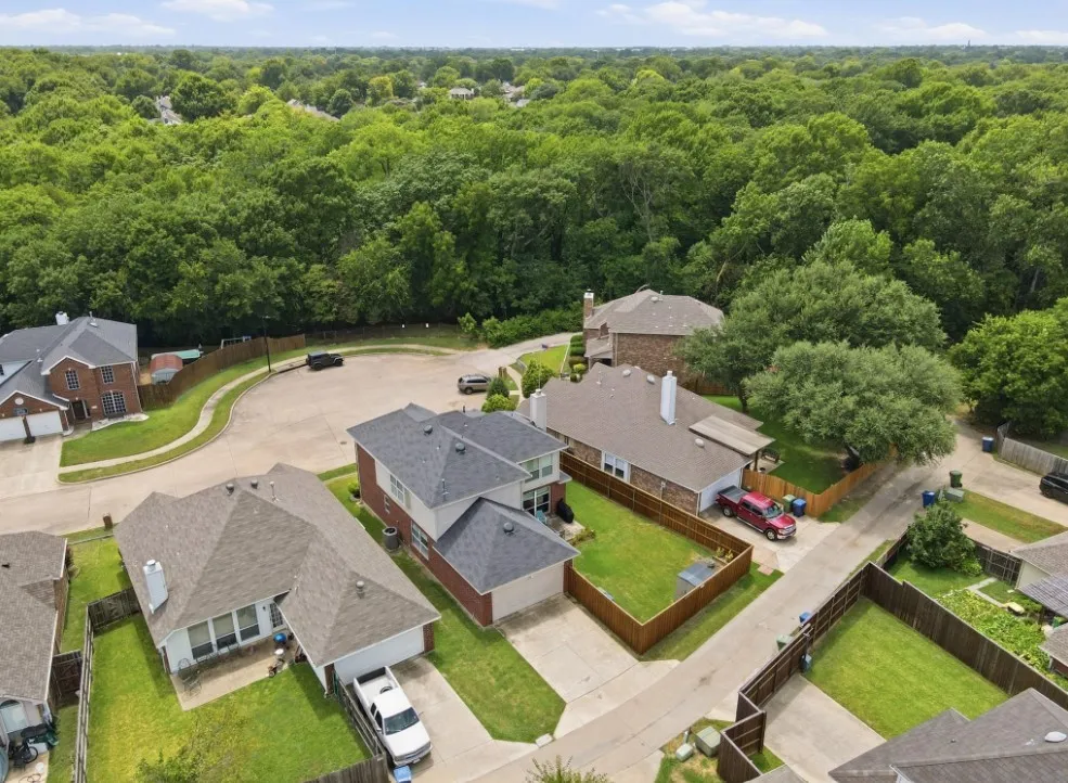 Aerial perspective of a cul-de-sac community featuring multiple residential properties with pitched roofs and attached garages