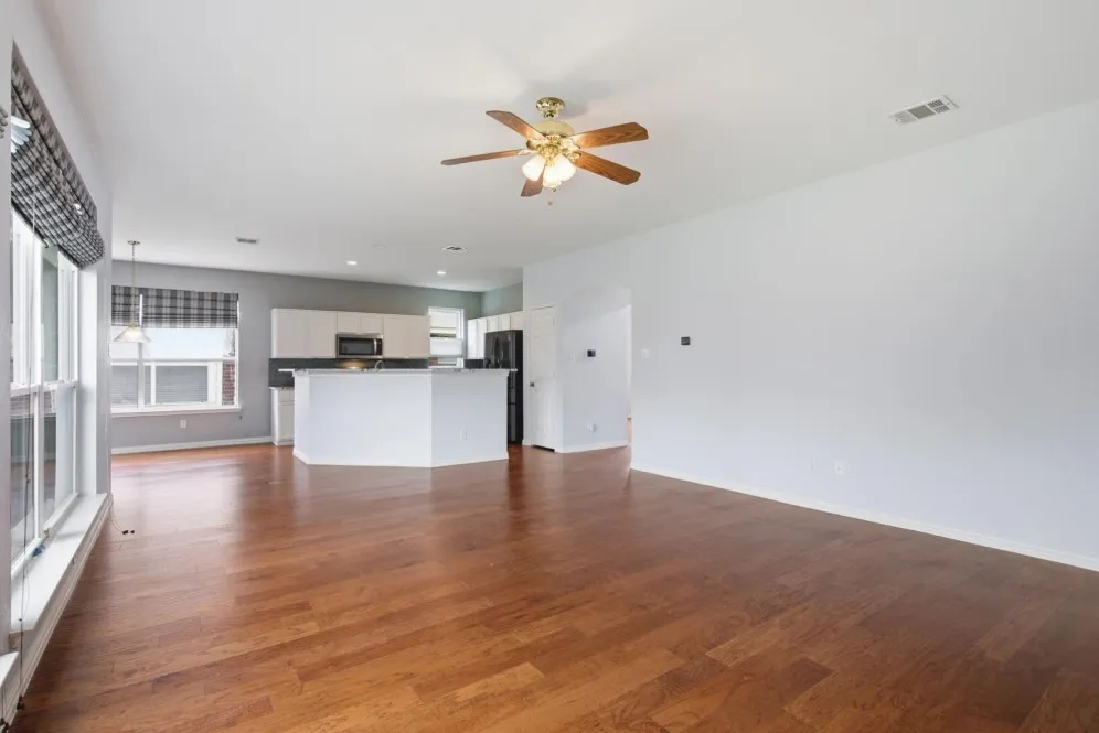 Wood-finish flooring throughout, with a ceiling fan and recessed lighting