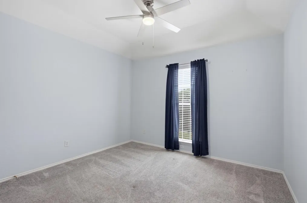 Recessed window featuring blinds, light gray wall finish, and gray carpet flooring