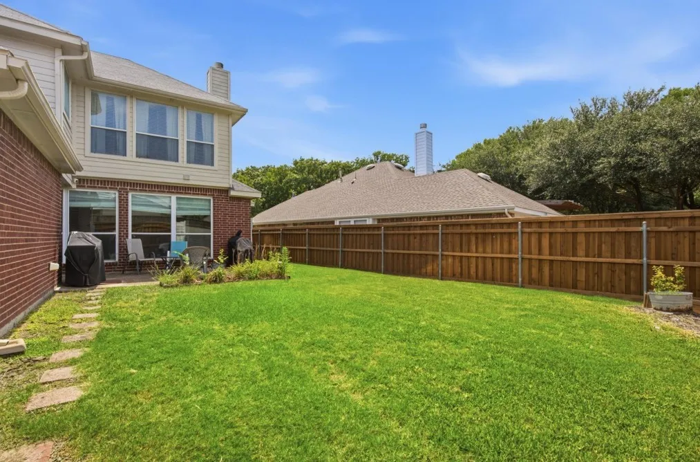 Expansive green lawn with a wood plank privacy fence