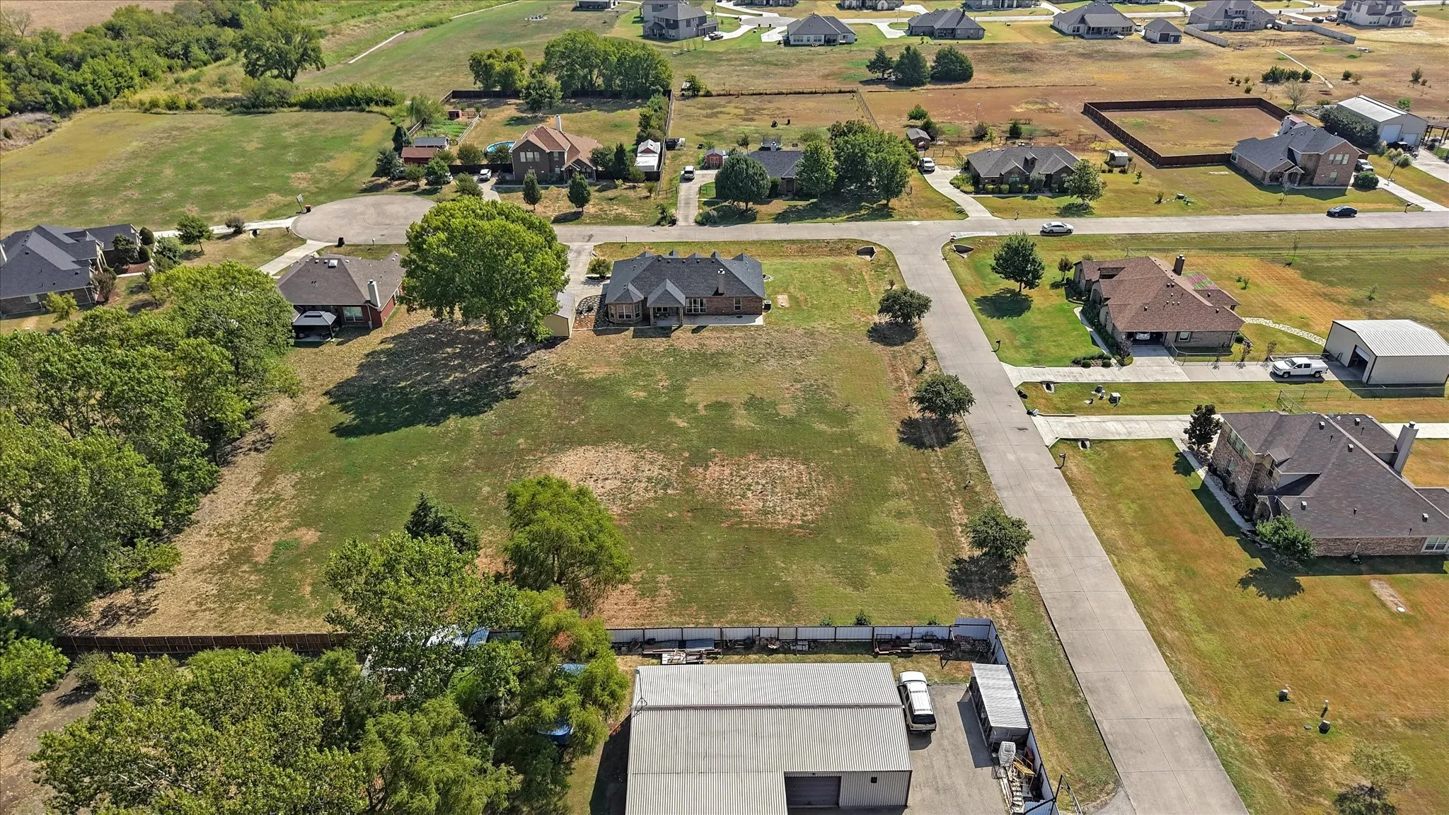Expansive lot featuring a large residential structure with a shingle roof and surrounding green space