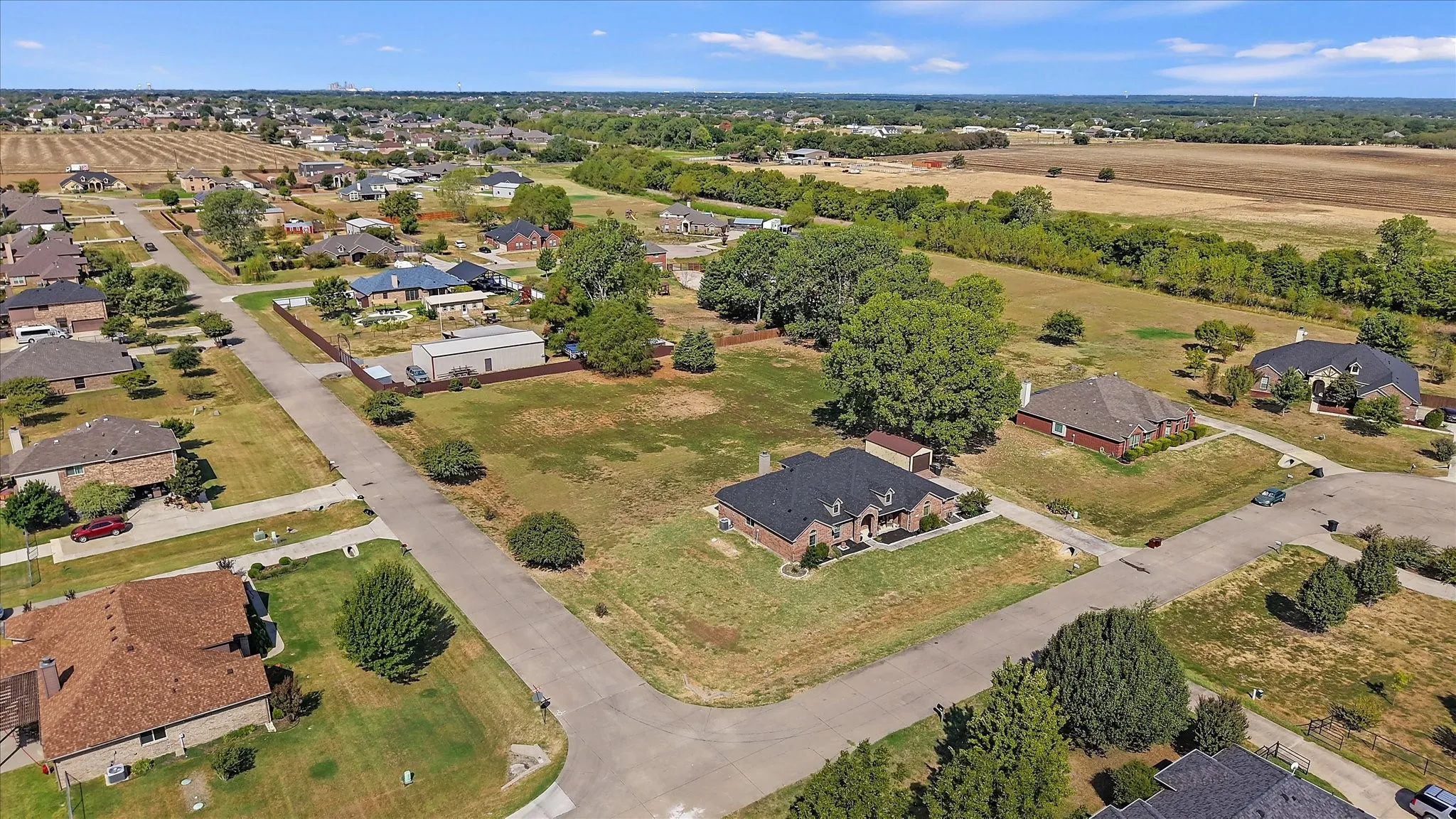 Aerial perspective showcasing residential properties and open land